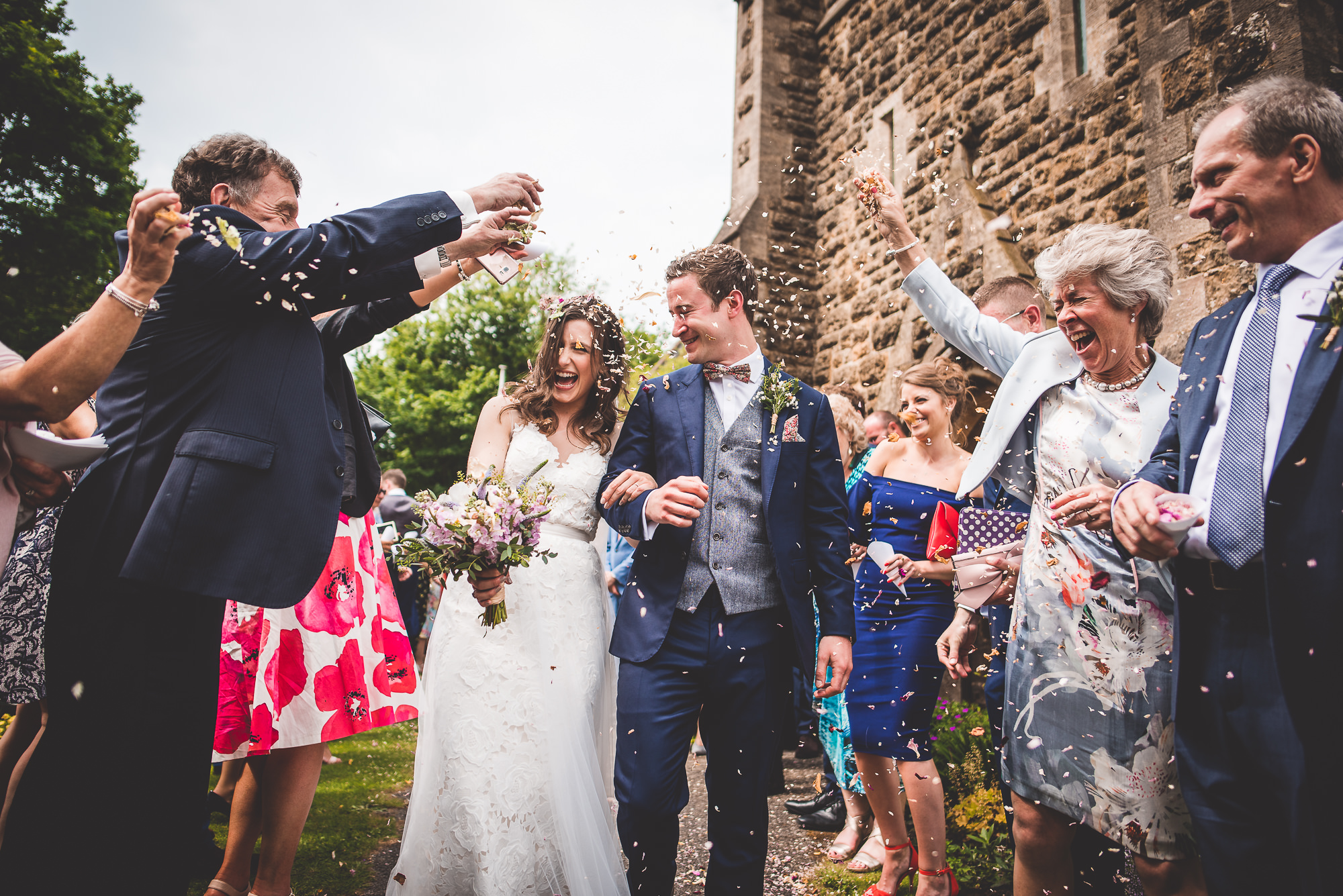 Bride and groom surrounded by confetti at their wedding.