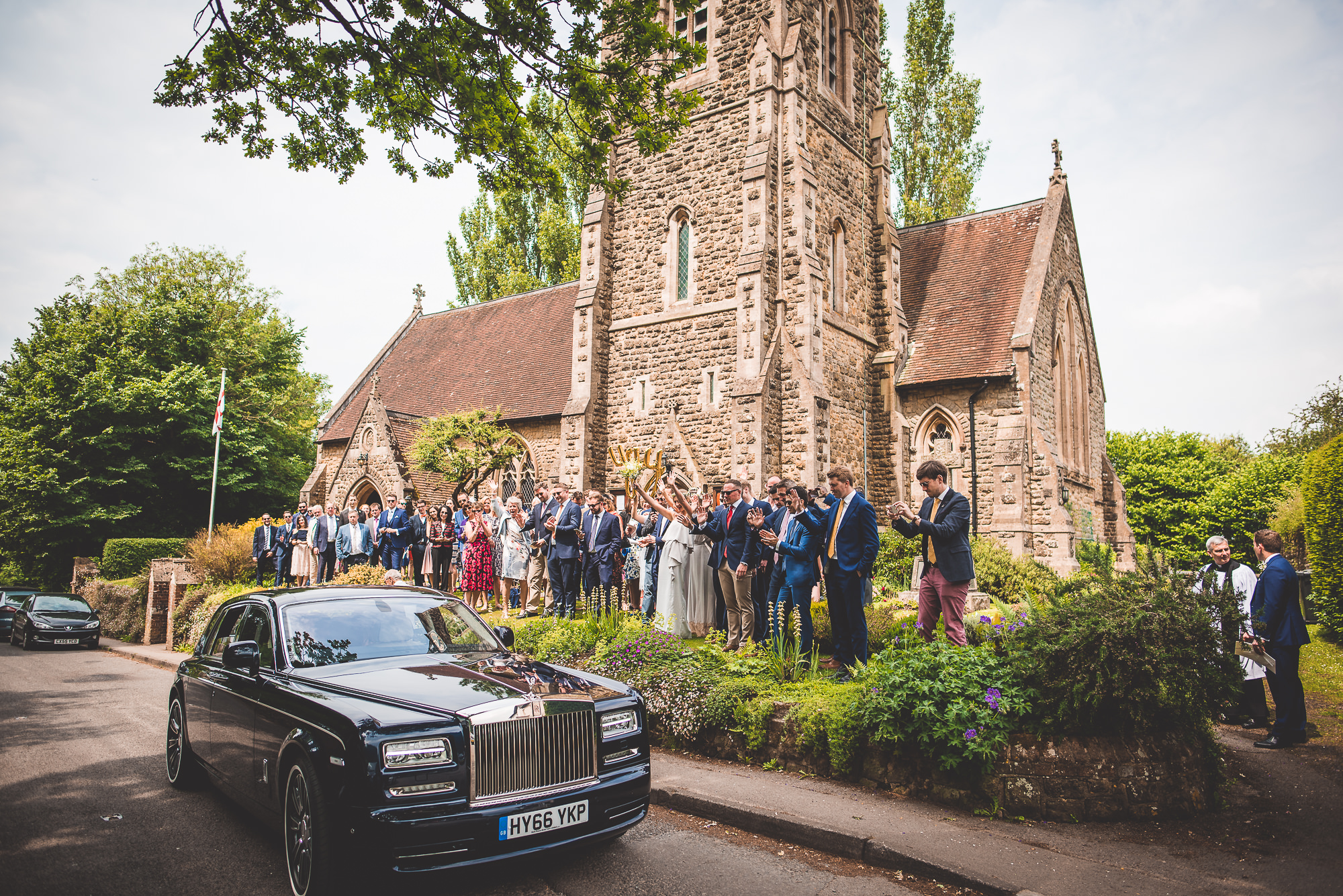 A wedding party posing for a photo in front of a church.