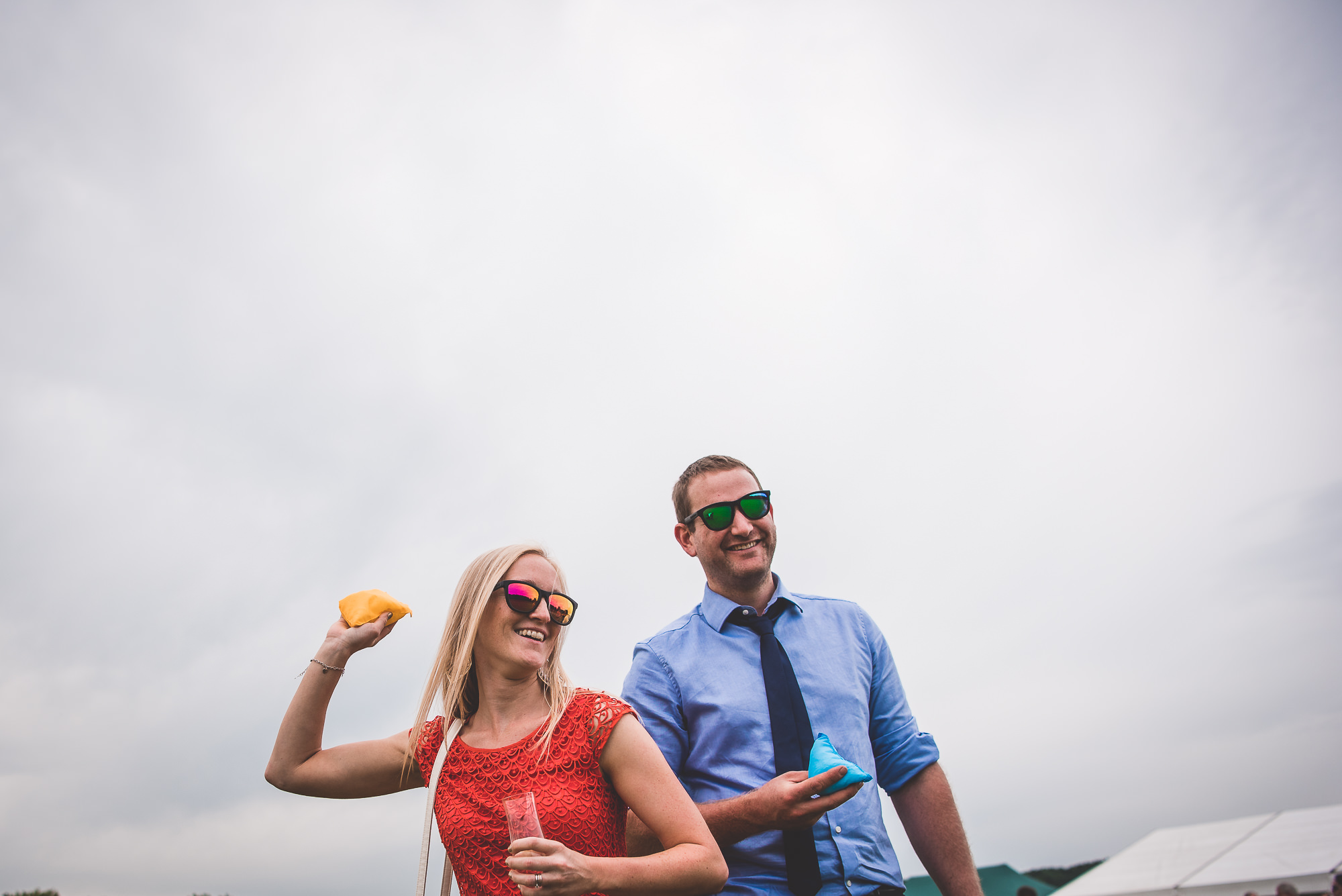 A bride and groom are standing on a grassy field.