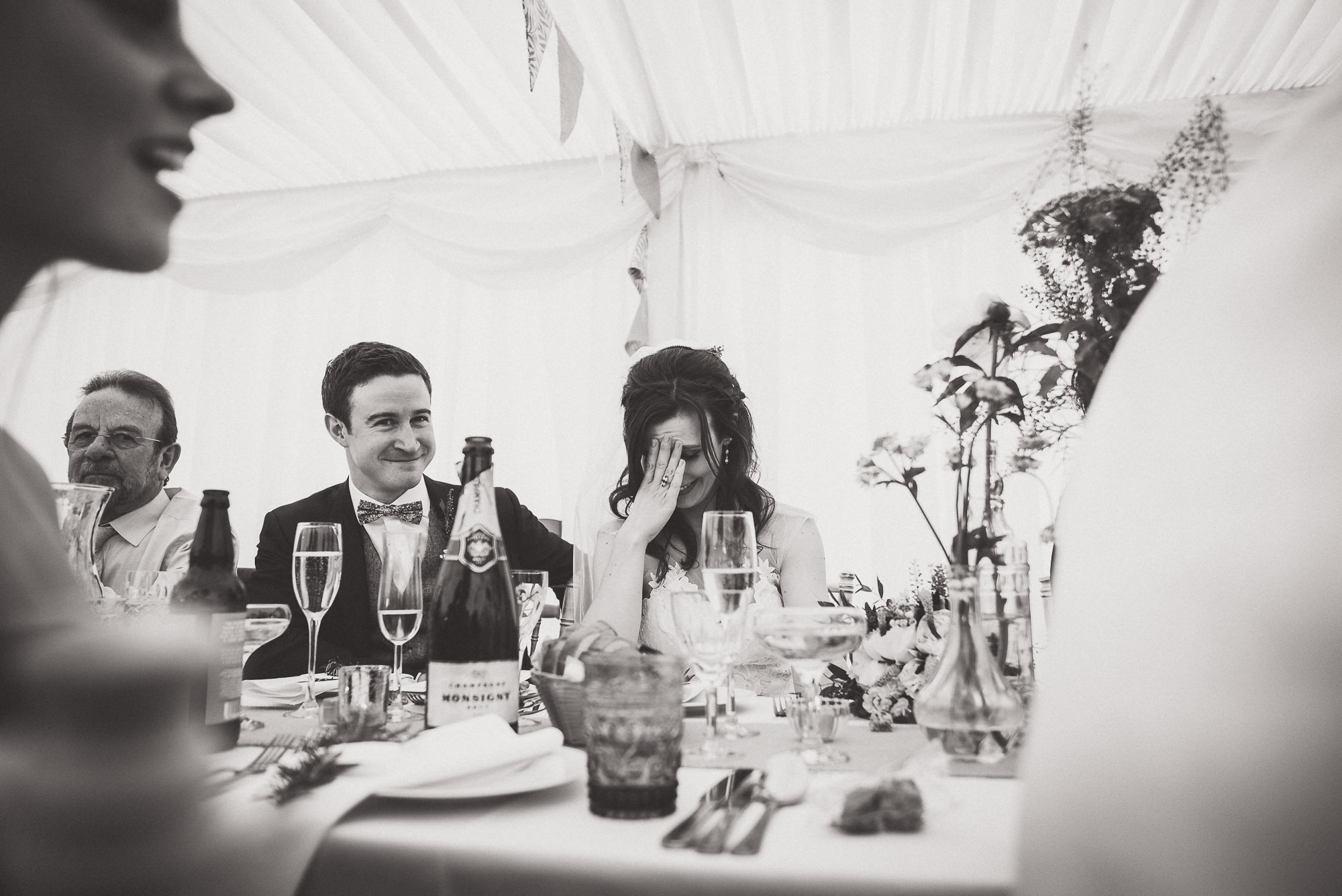 A wedding photographer captured a black and white photo of the groom and bride.