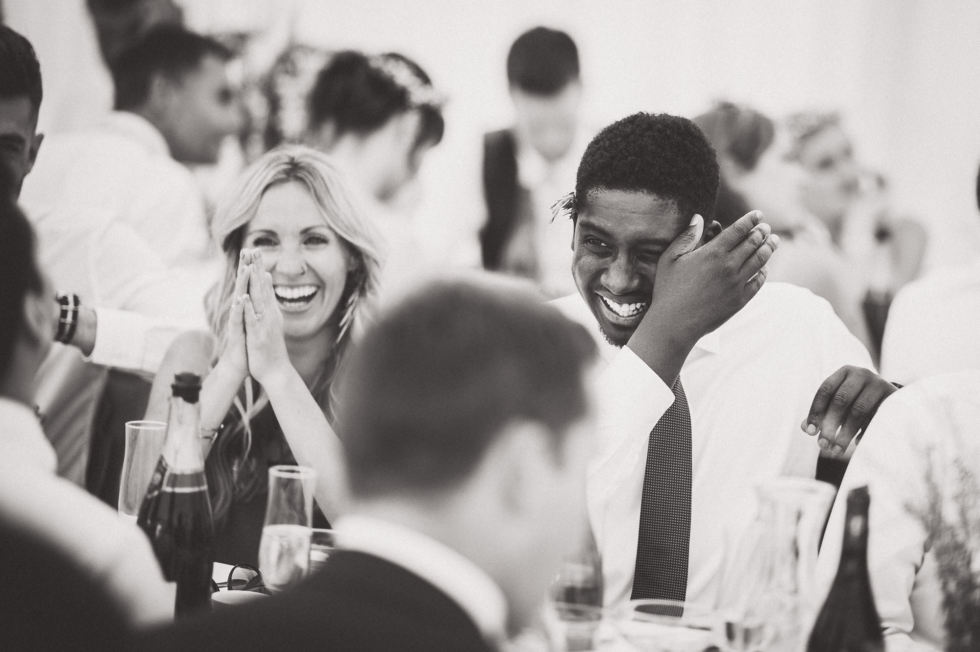 A group of wedding guests laughing at the reception.