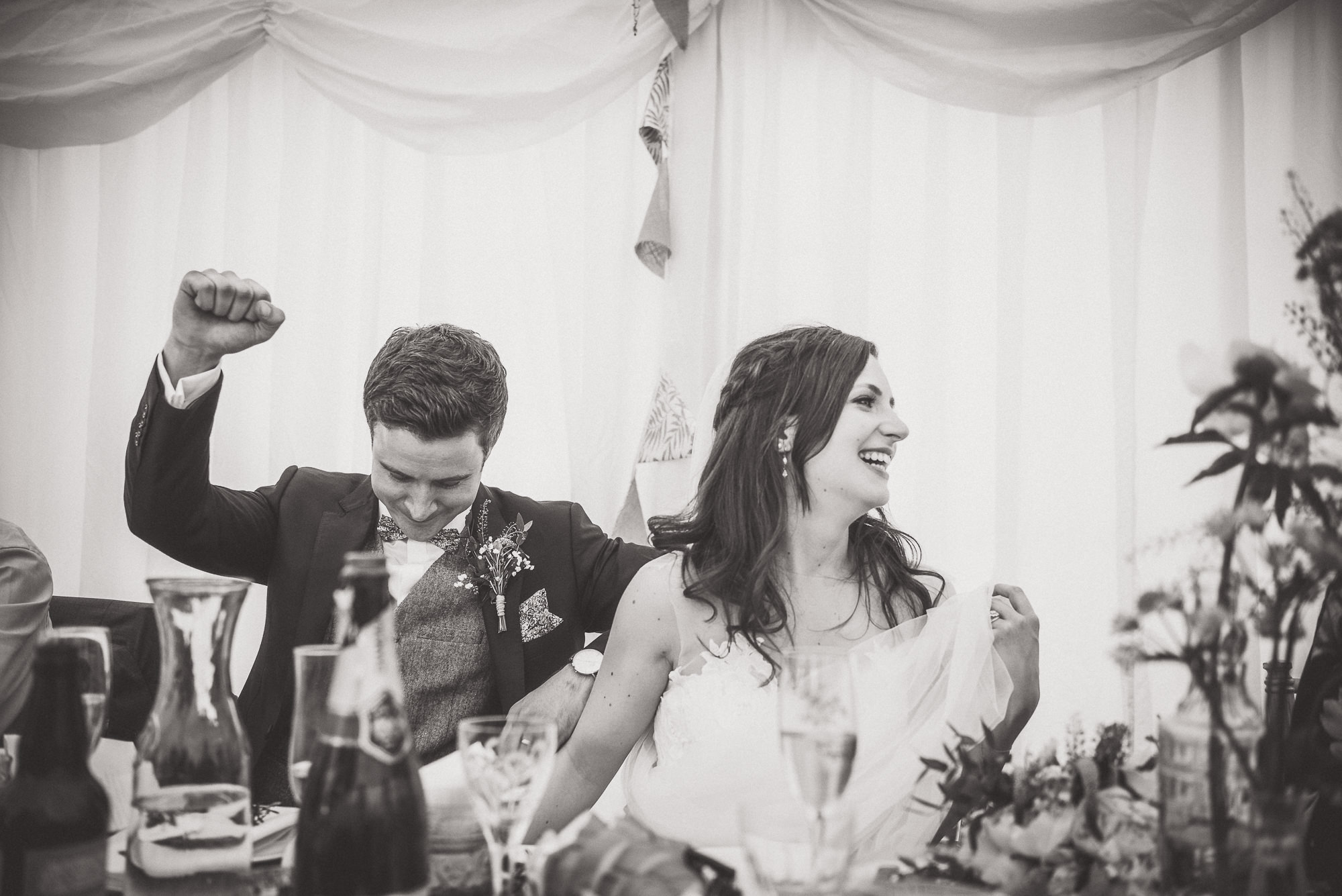 A bride and groom celebrating their wedding with an energetic photo.