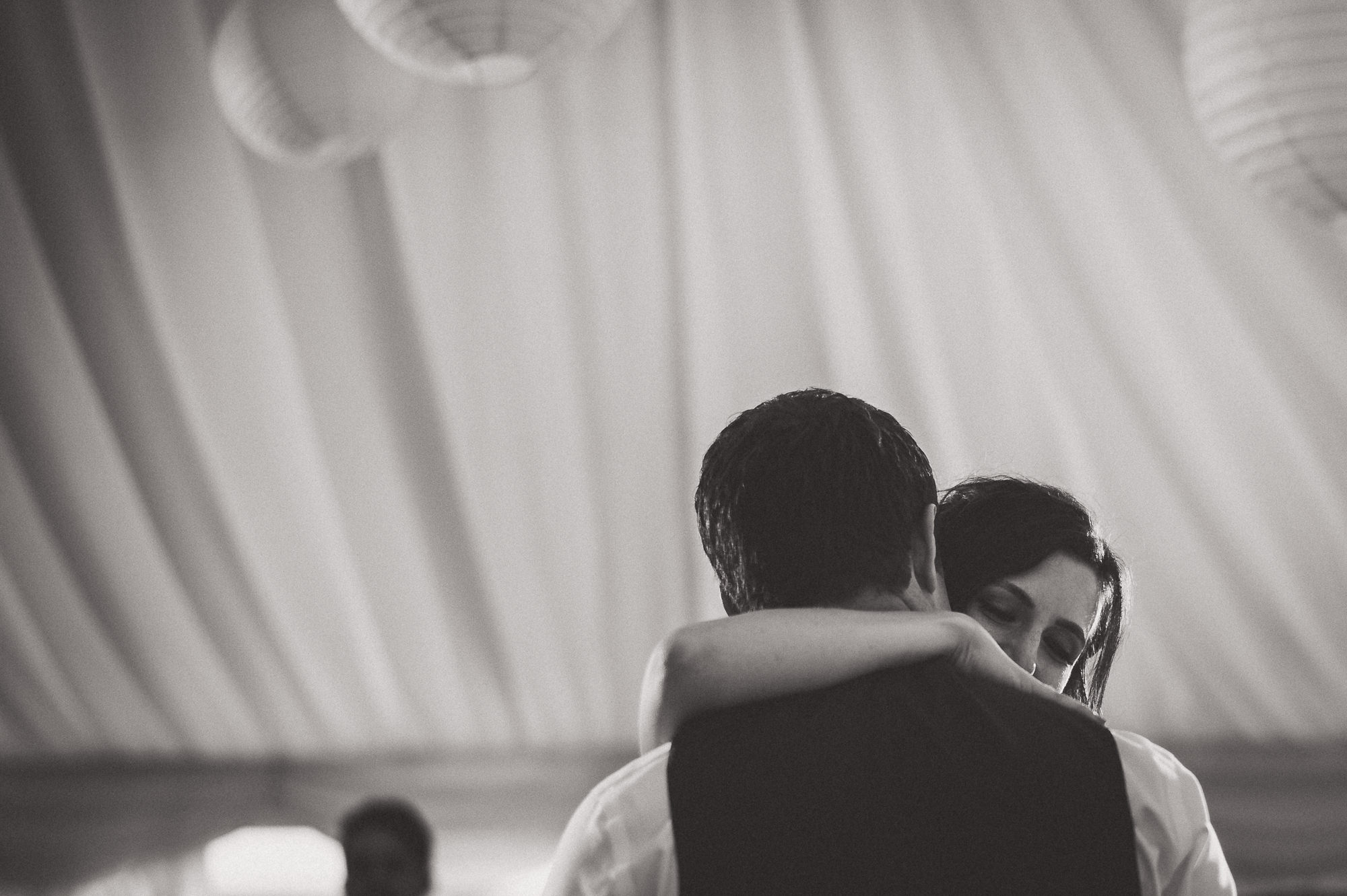 A groom hugging his bride during their first wedding dance.