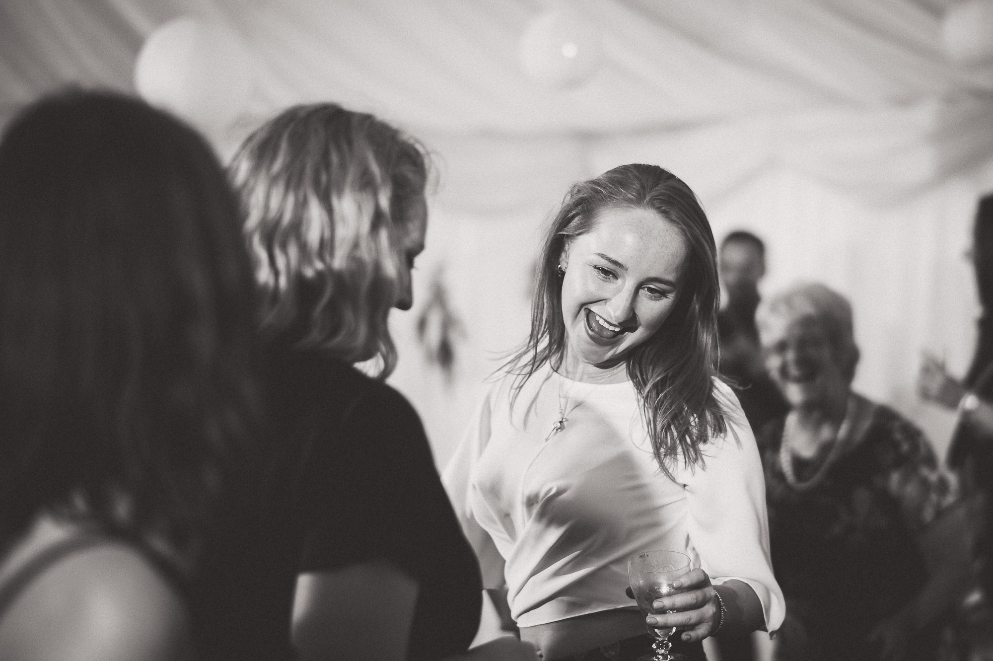 Black and white photo of a woman enjoying a wedding.