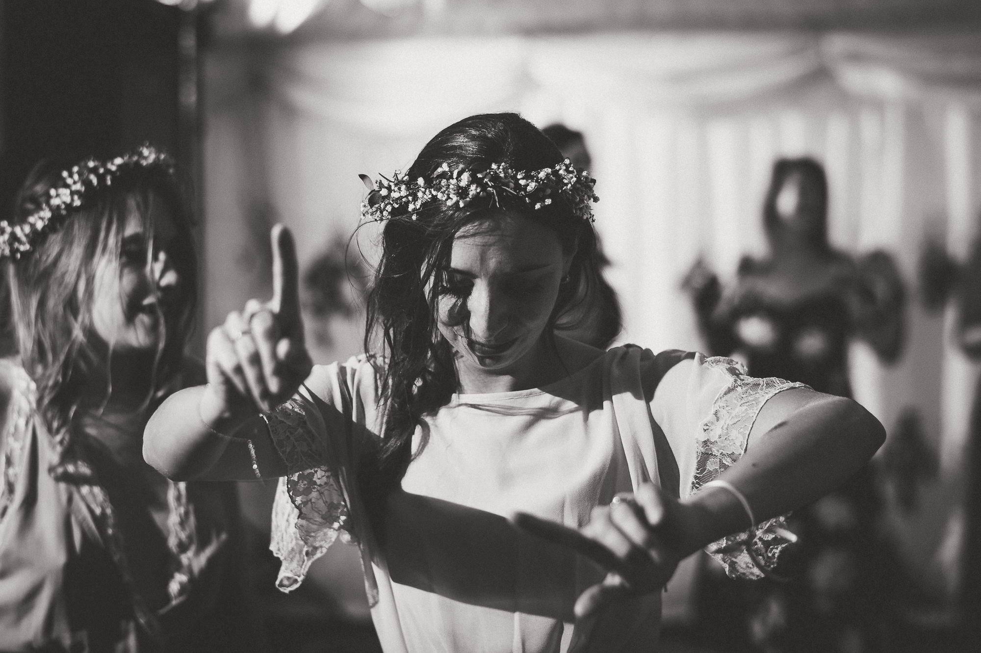 A wedding photographer captures a groom and bride dancing at the wedding.