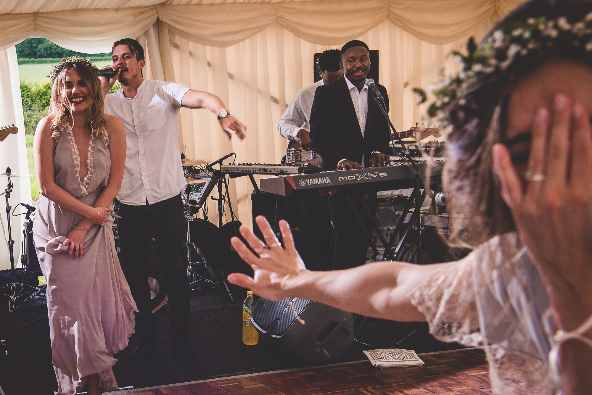 A bride is posing with her hand up during a wedding photoshoot.