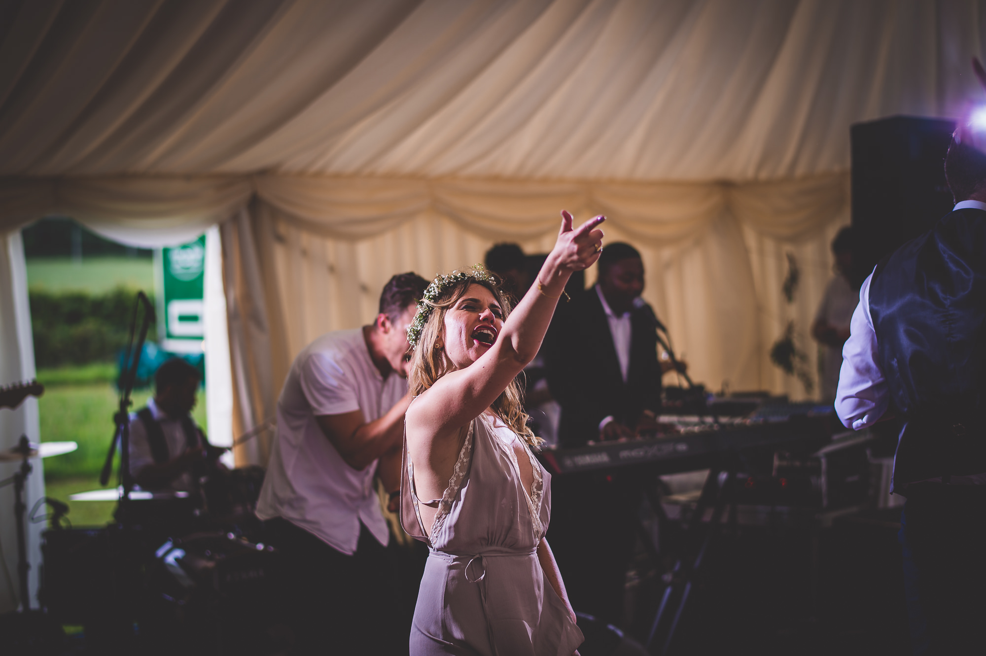 A wedding photo capturing the bride and groom in a tent.