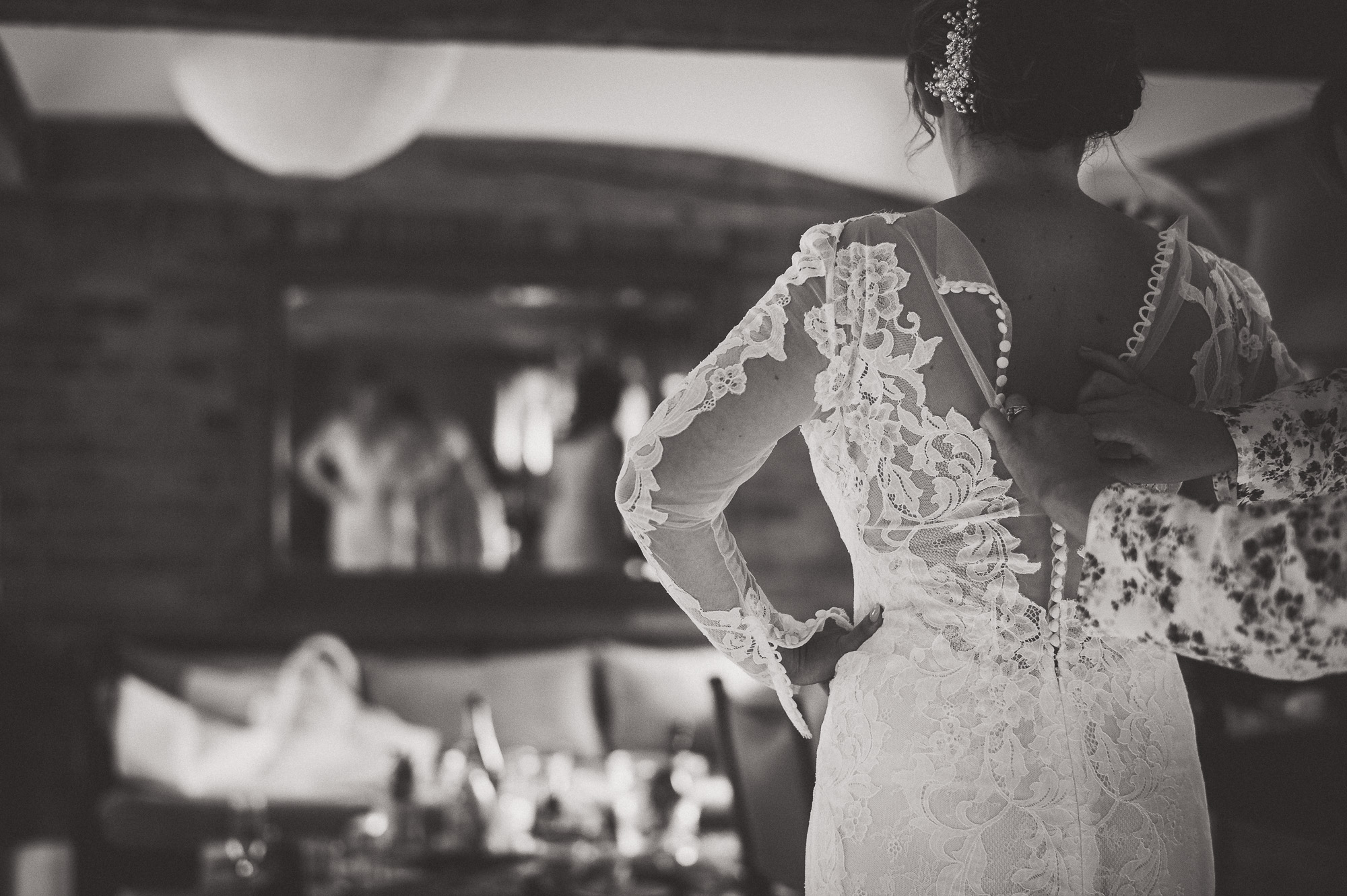 A bride is getting ready for her wedding while being photographed by a wedding photographer.