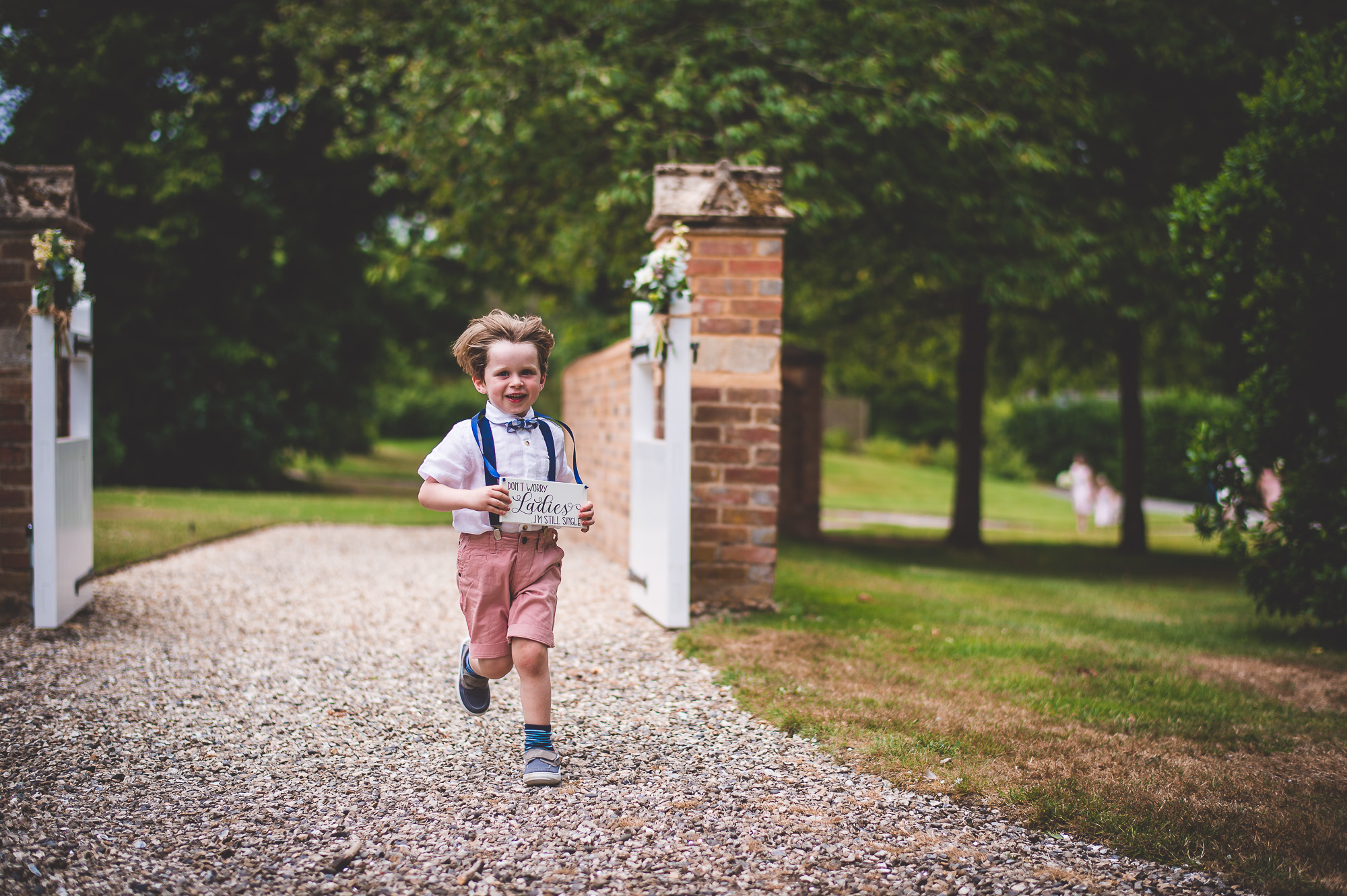 A little boy running down the aisle during a wedding ceremony.