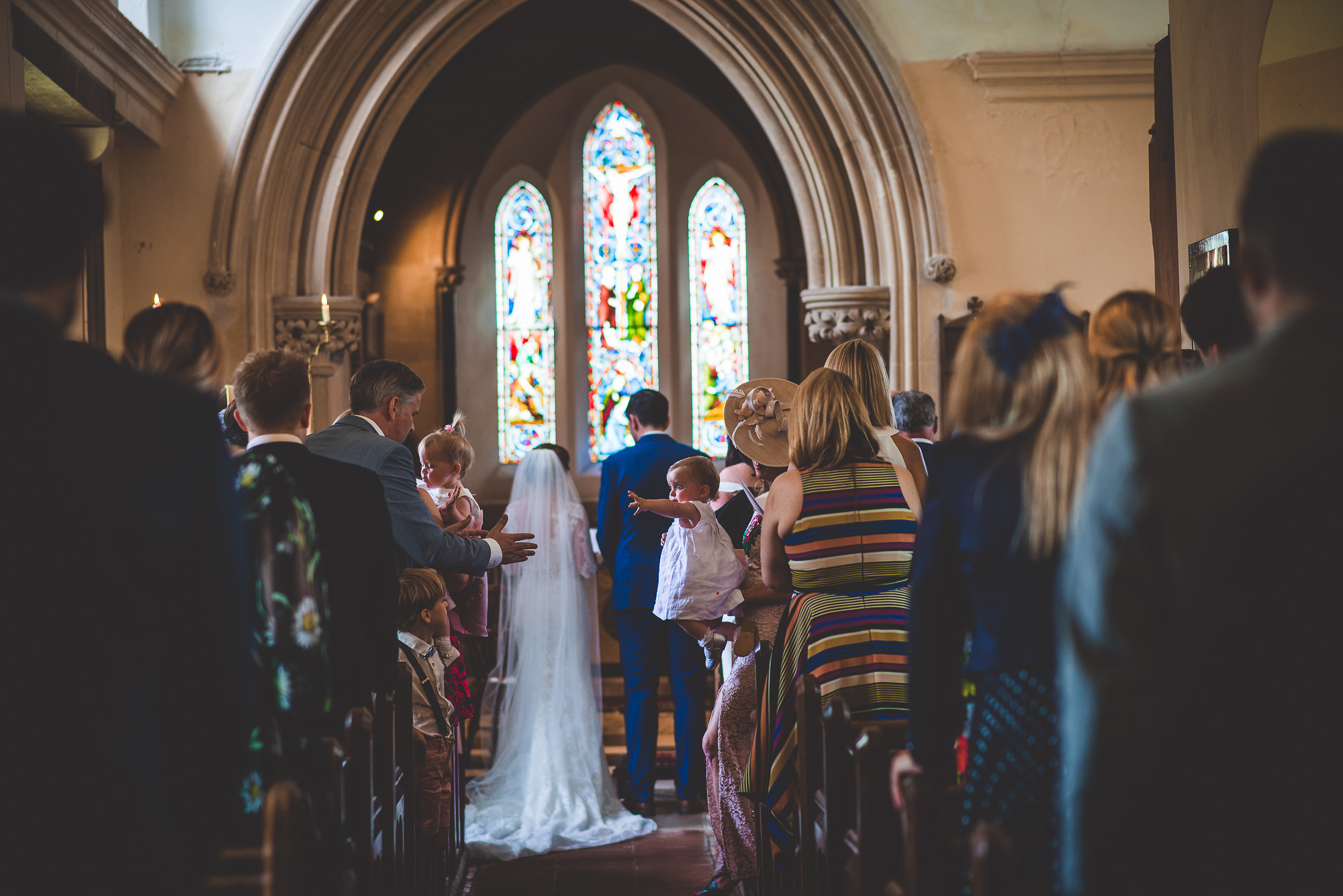 A bride and groom captured by a wedding photographer walking down the aisle in a church.