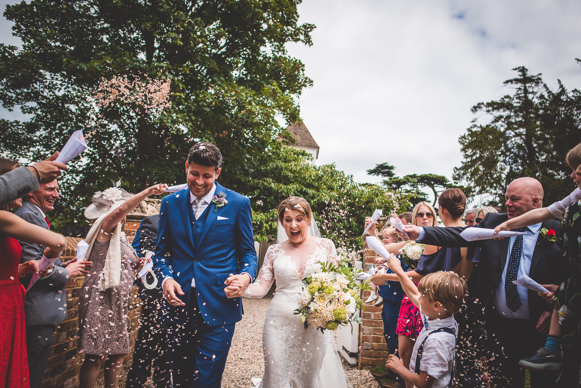 A wedding photographer captures a memorable moment of a bride and groom walking down the aisle amidst confetti.