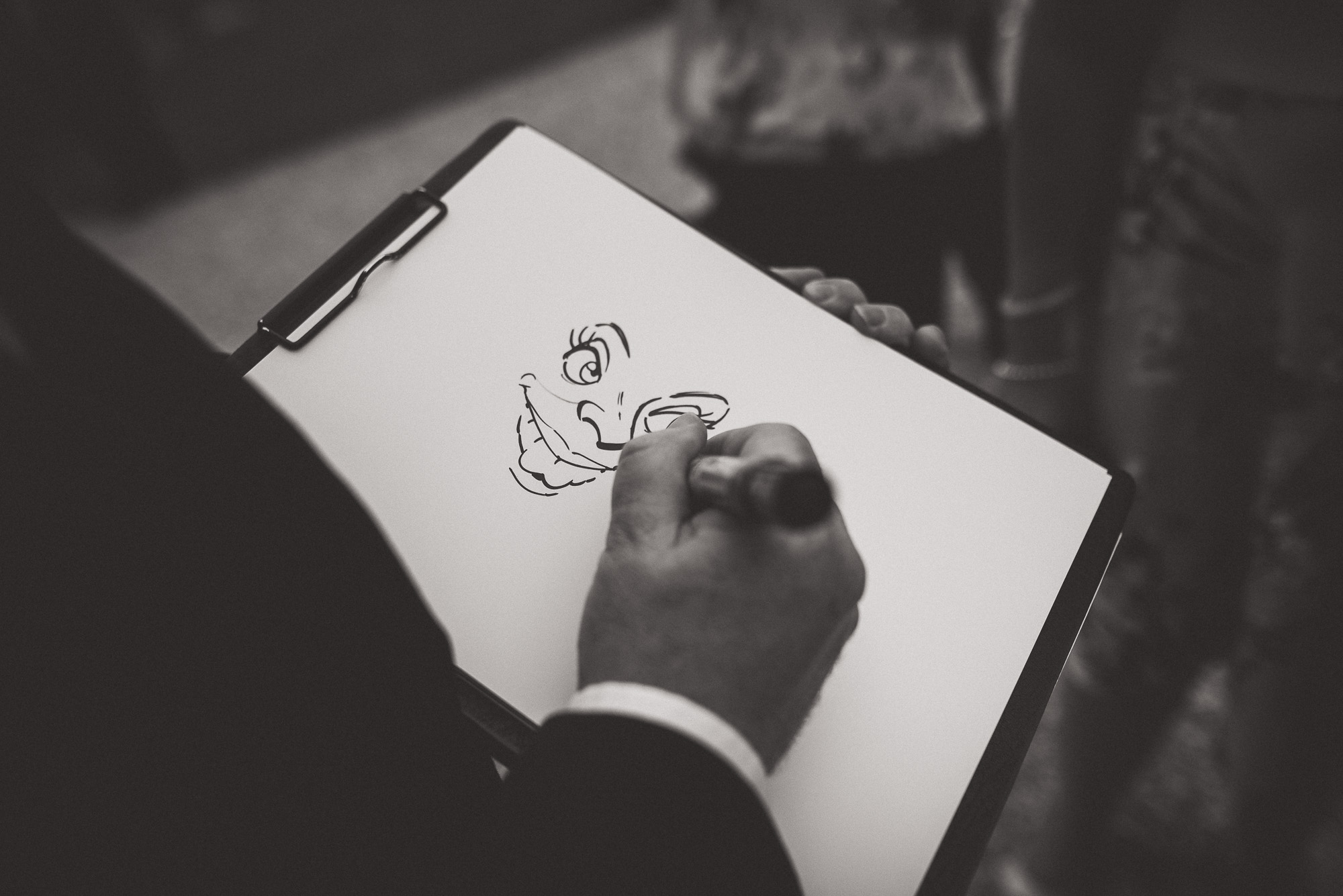 A groom sketching a face on a piece of paper.
