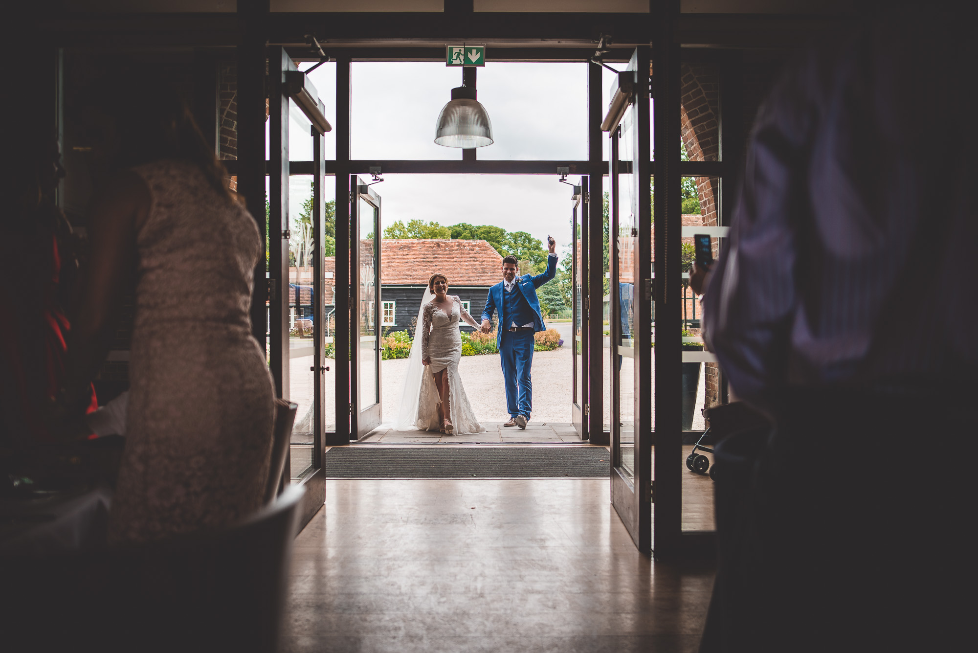 A bride and groom captured by a wedding photographer as they exit a doorway.