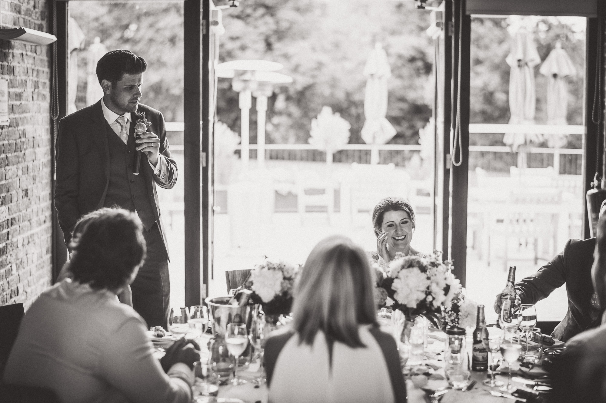 A wedding photographer captures a groom giving a speech.
