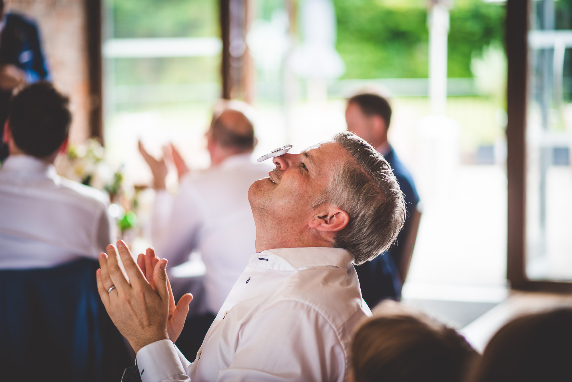 A bride's wedding photo with a man clapping at the reception.