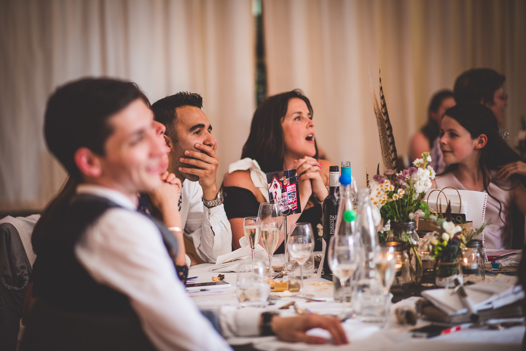 A group of people at a wedding table with the bride and a wedding photographer.