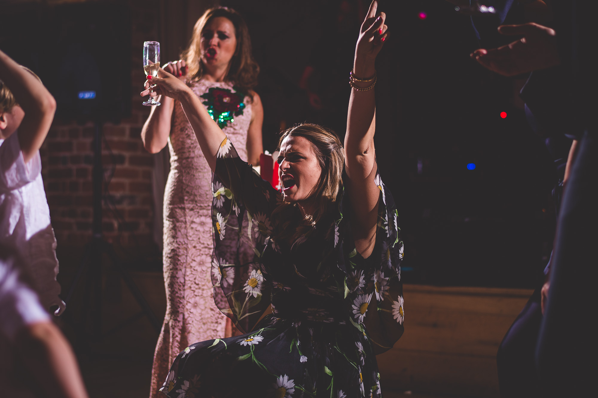 A woman is holding up a glass of champagne at a wedding reception, capturing a memorable wedding photo.