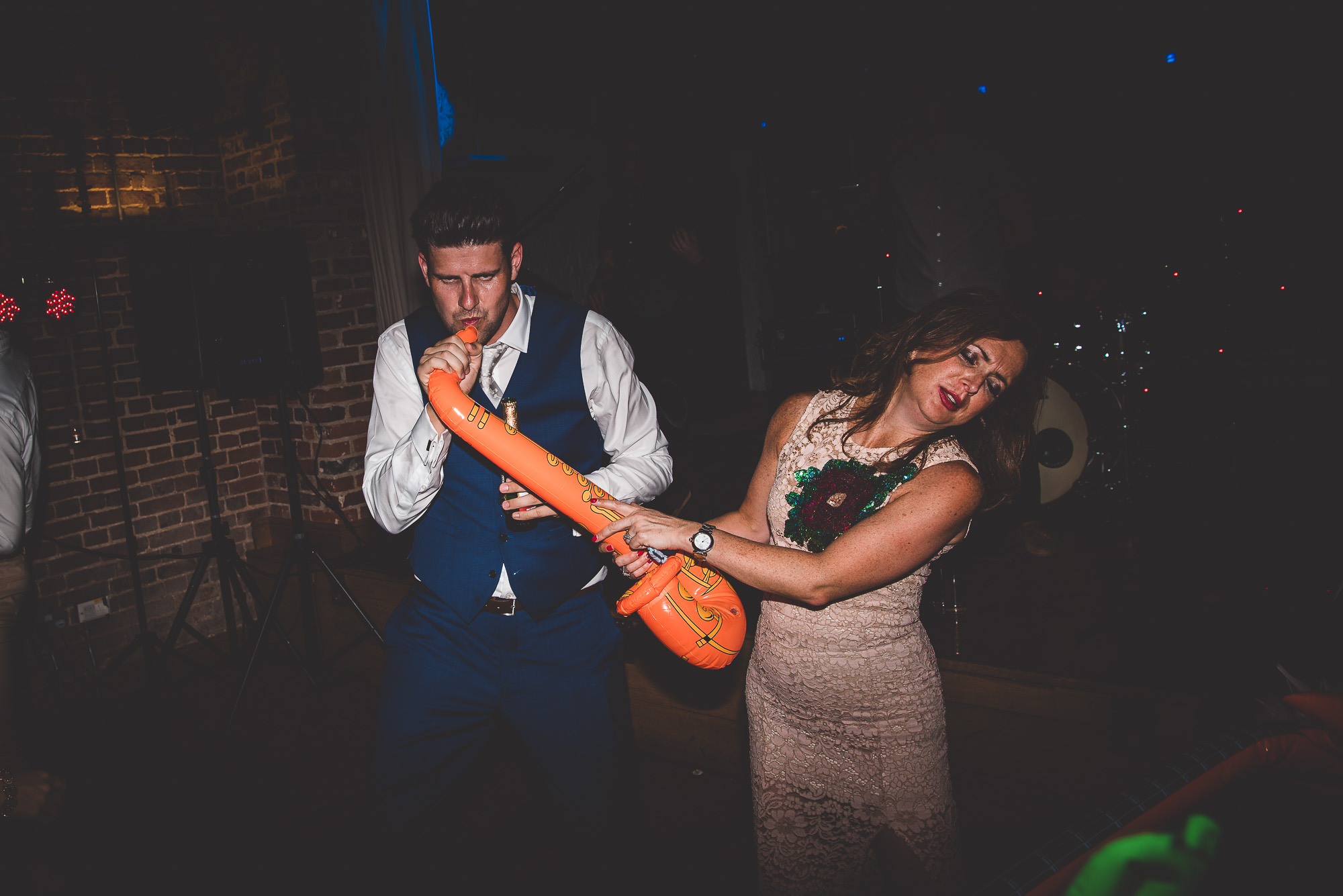 A groom and wedding photographer capturing the dancing couple at a wedding reception.