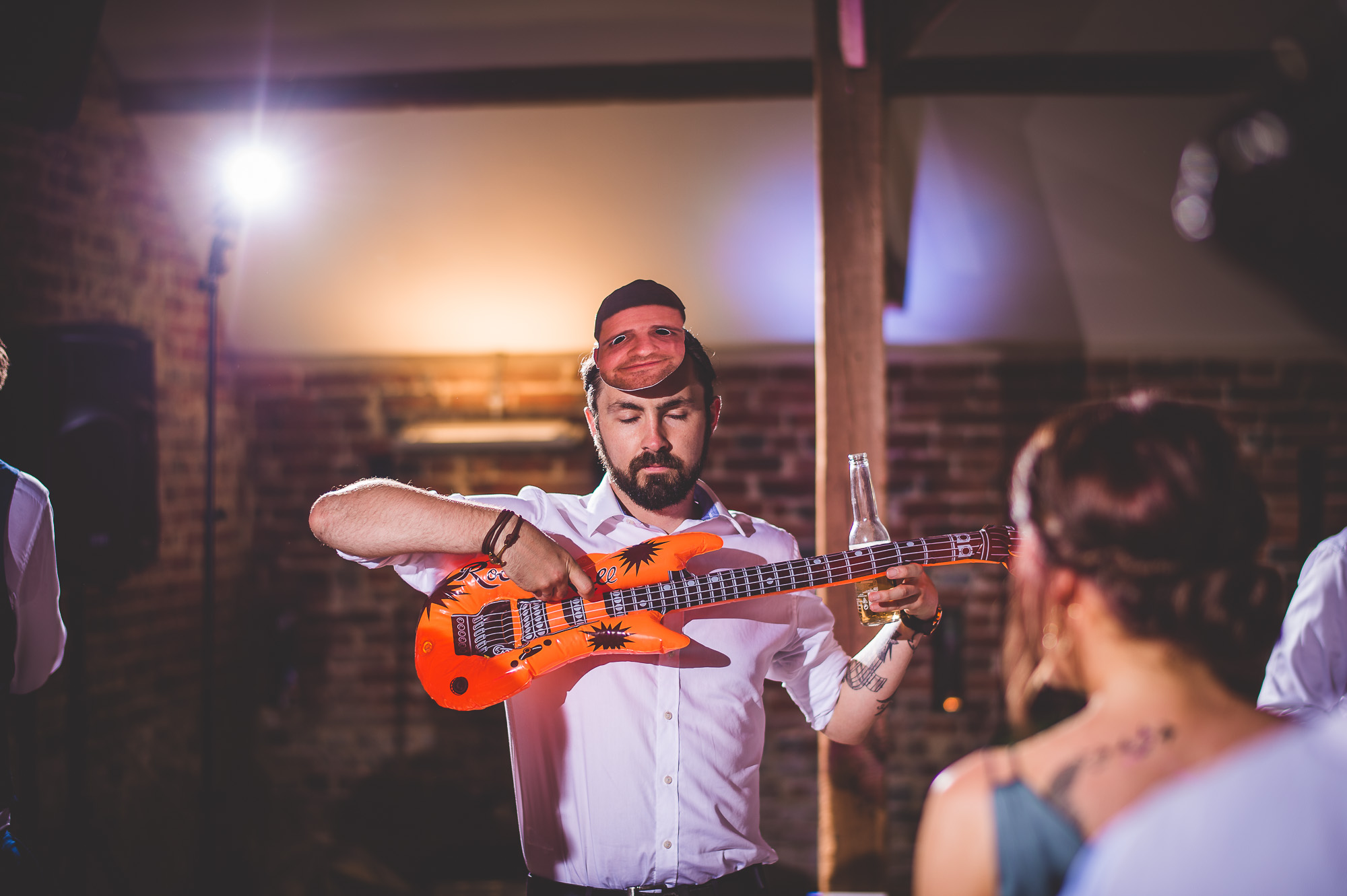 A groom playing a guitar at his wedding.