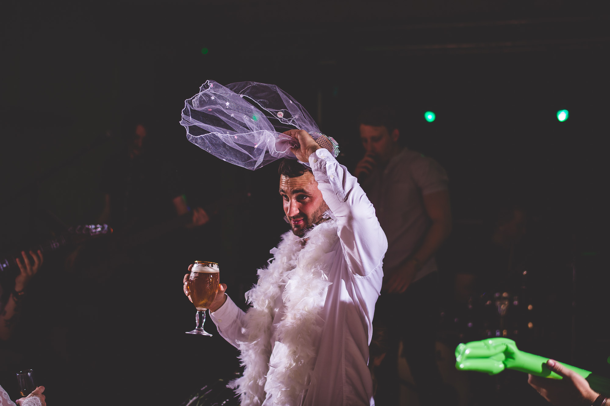 A wedding photographer captures an image of the bride holding a glass of wine.