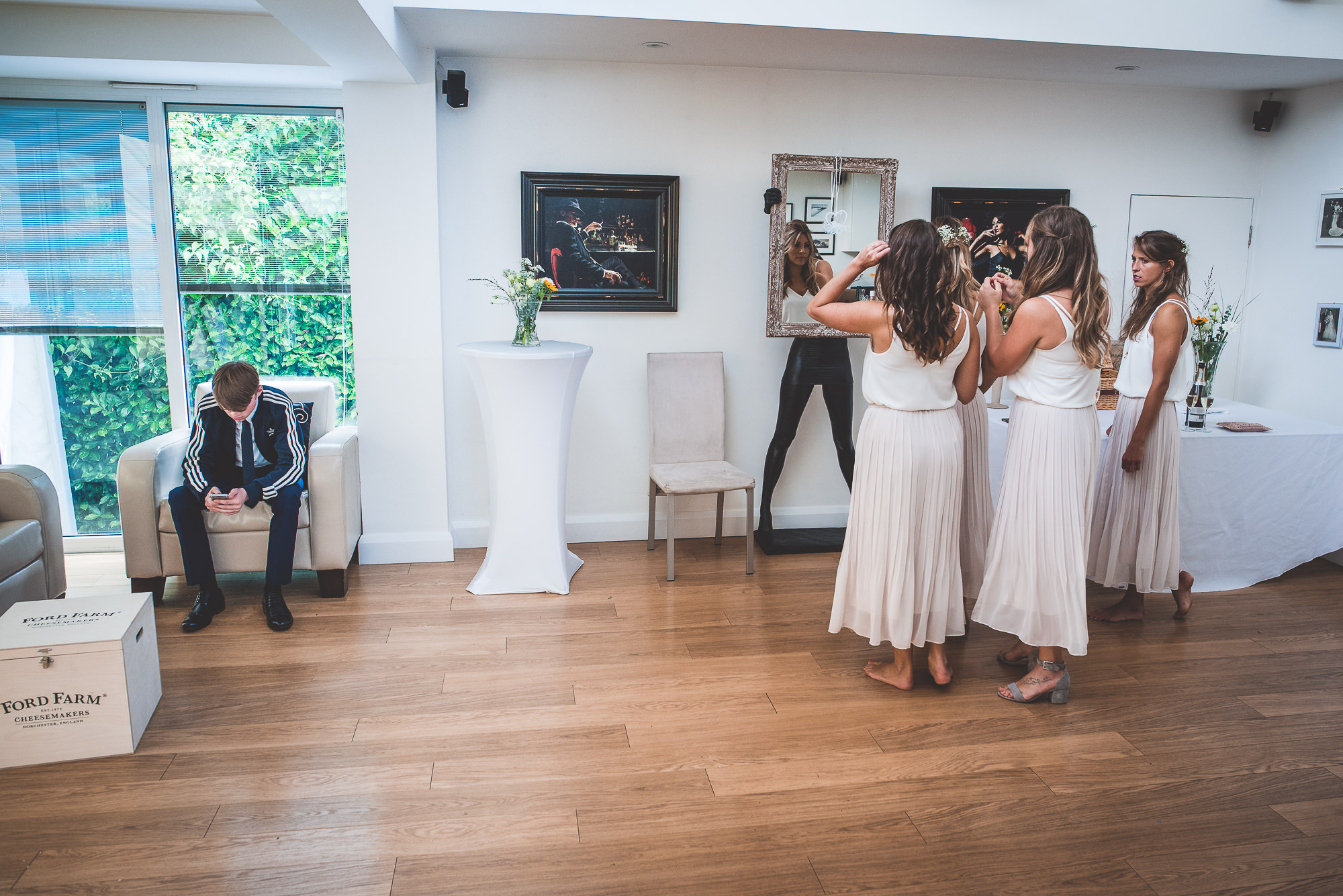 A group of bridesmaids standing in front of a mirror during a wedding.