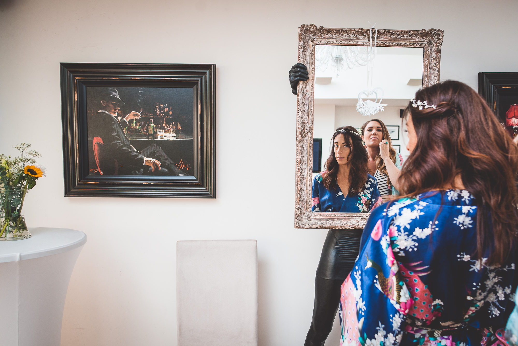 A bride in a kimono is looking at herself in a mirror on her wedding day.