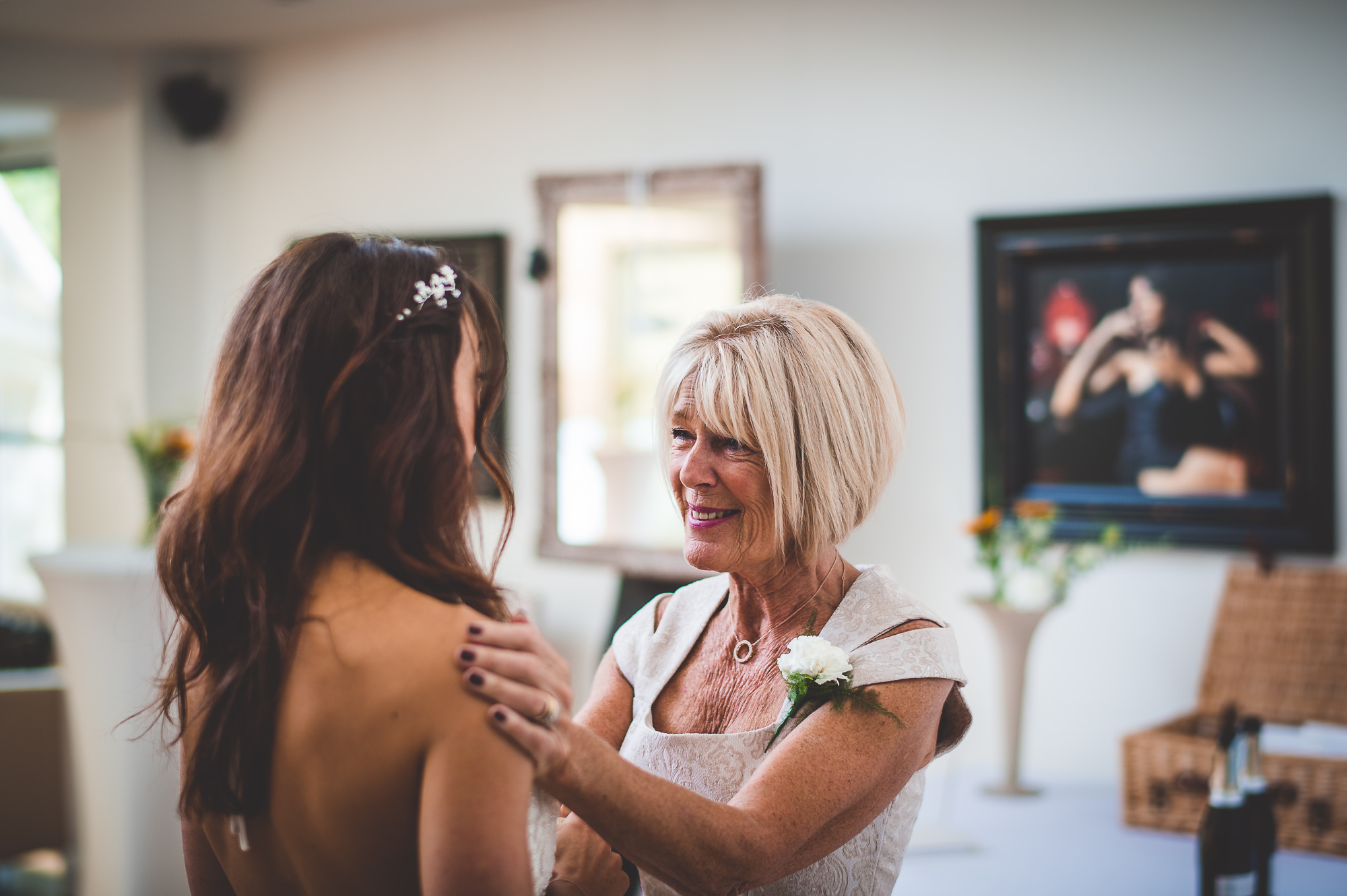A woman is assisting her mother in getting ready for her big day as the bride.