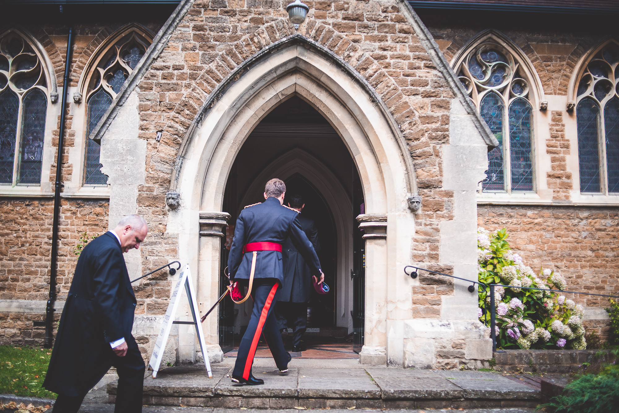 A groom in a suit walking down the steps of a church.
