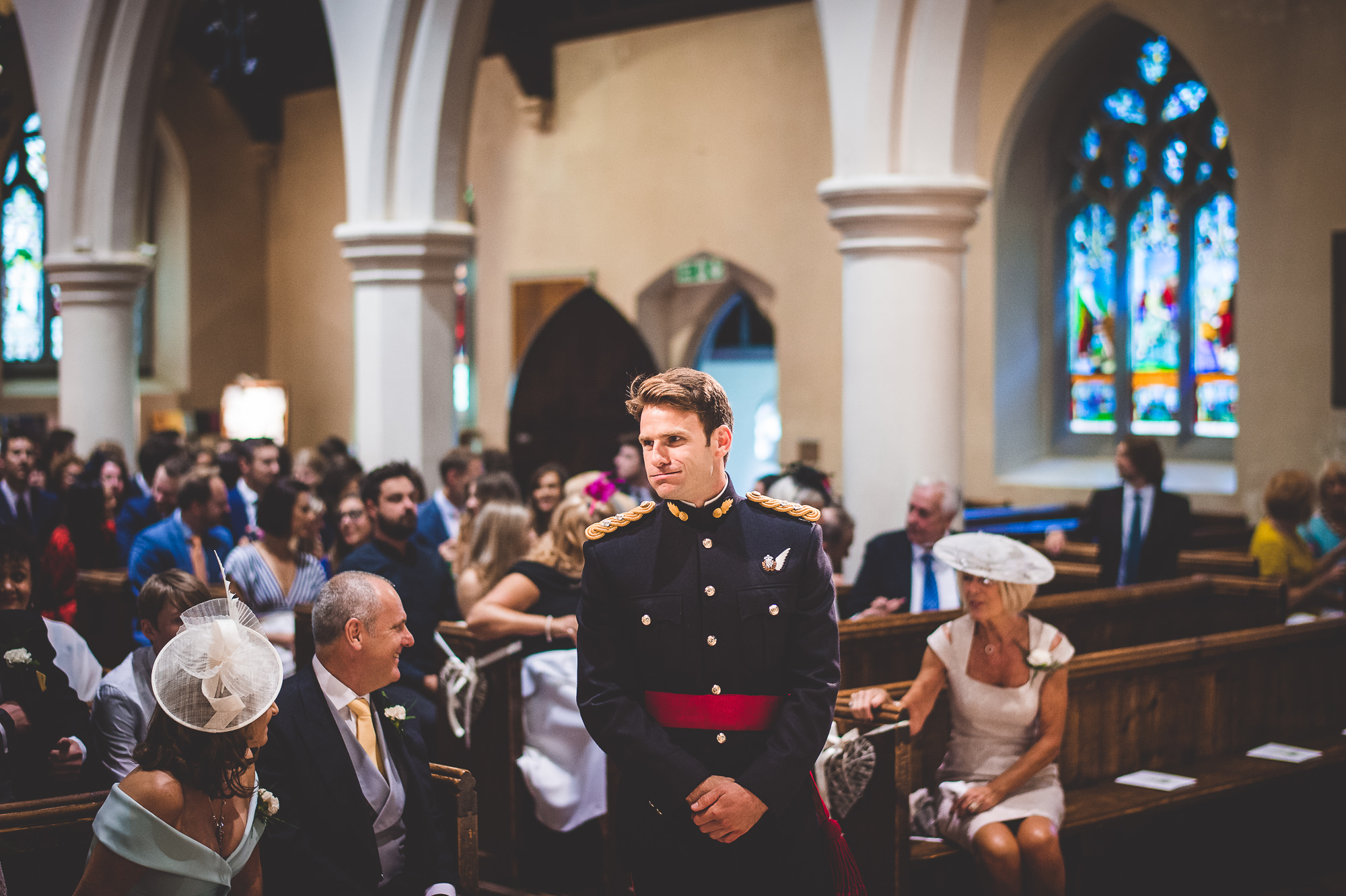 A man in a military uniform standing next to the bride in a wedding photo inside a church.