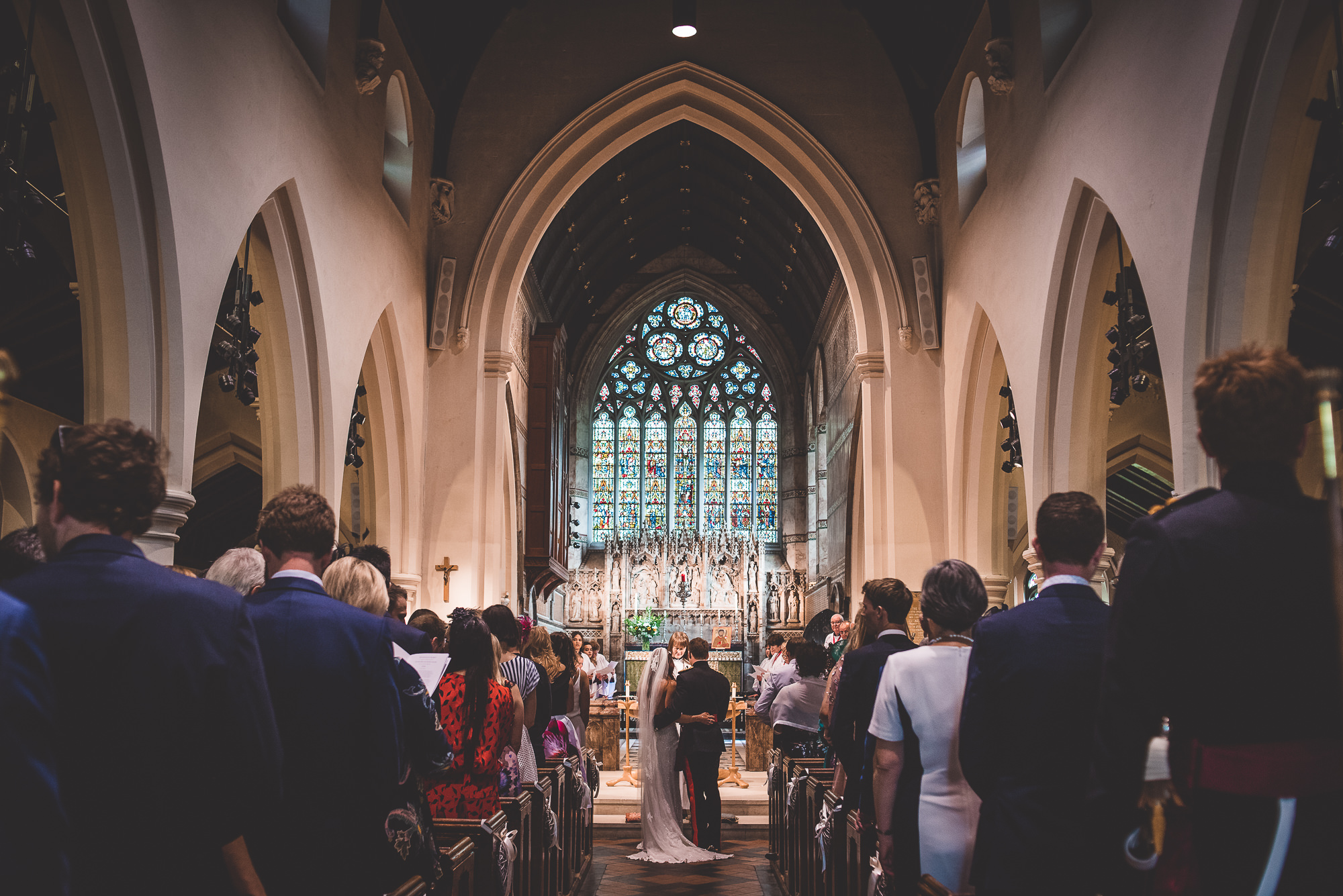 A bride and groom's wedding photo, captured as they walk down the aisle of a church.
