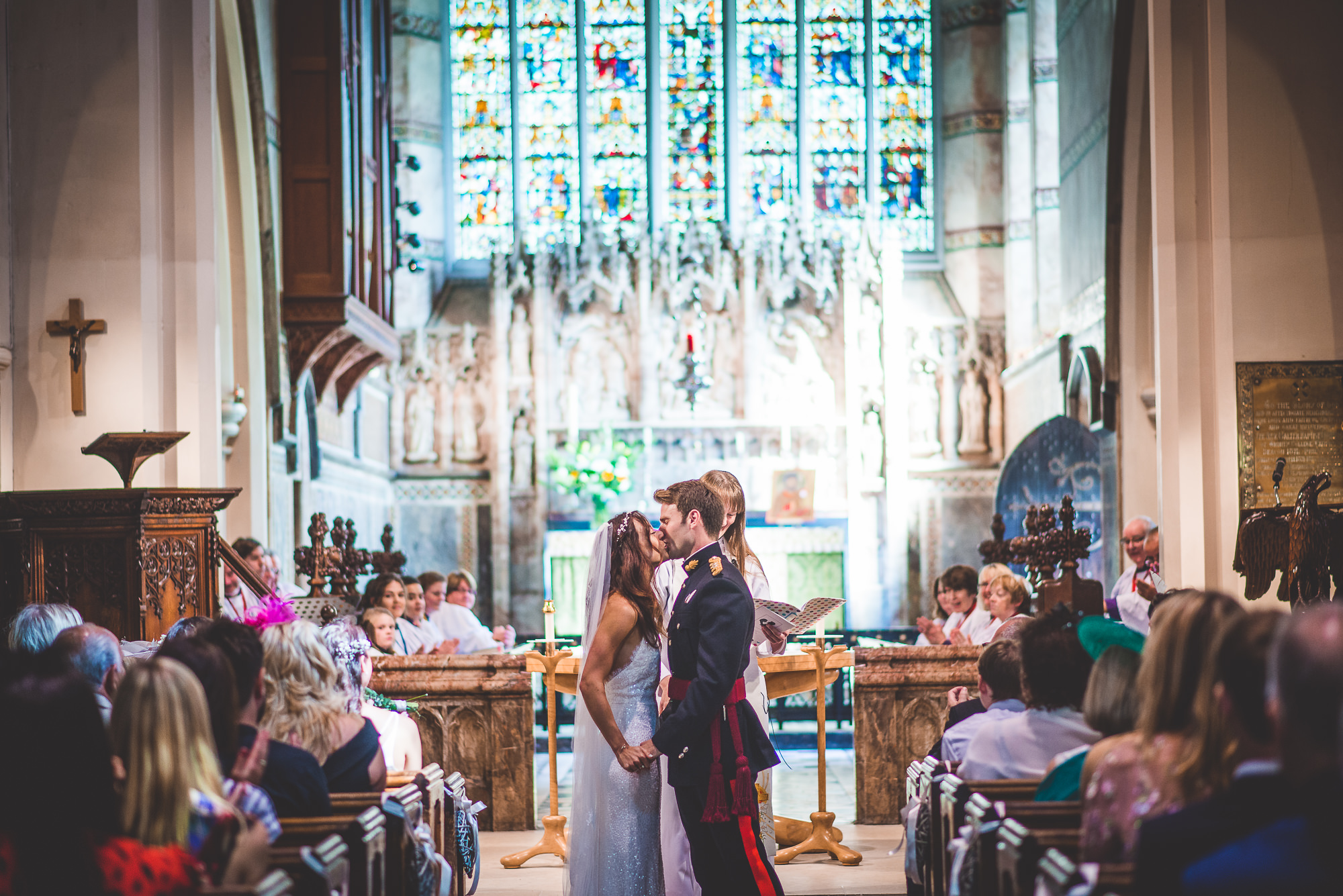 A wedding couple kissing in a church.