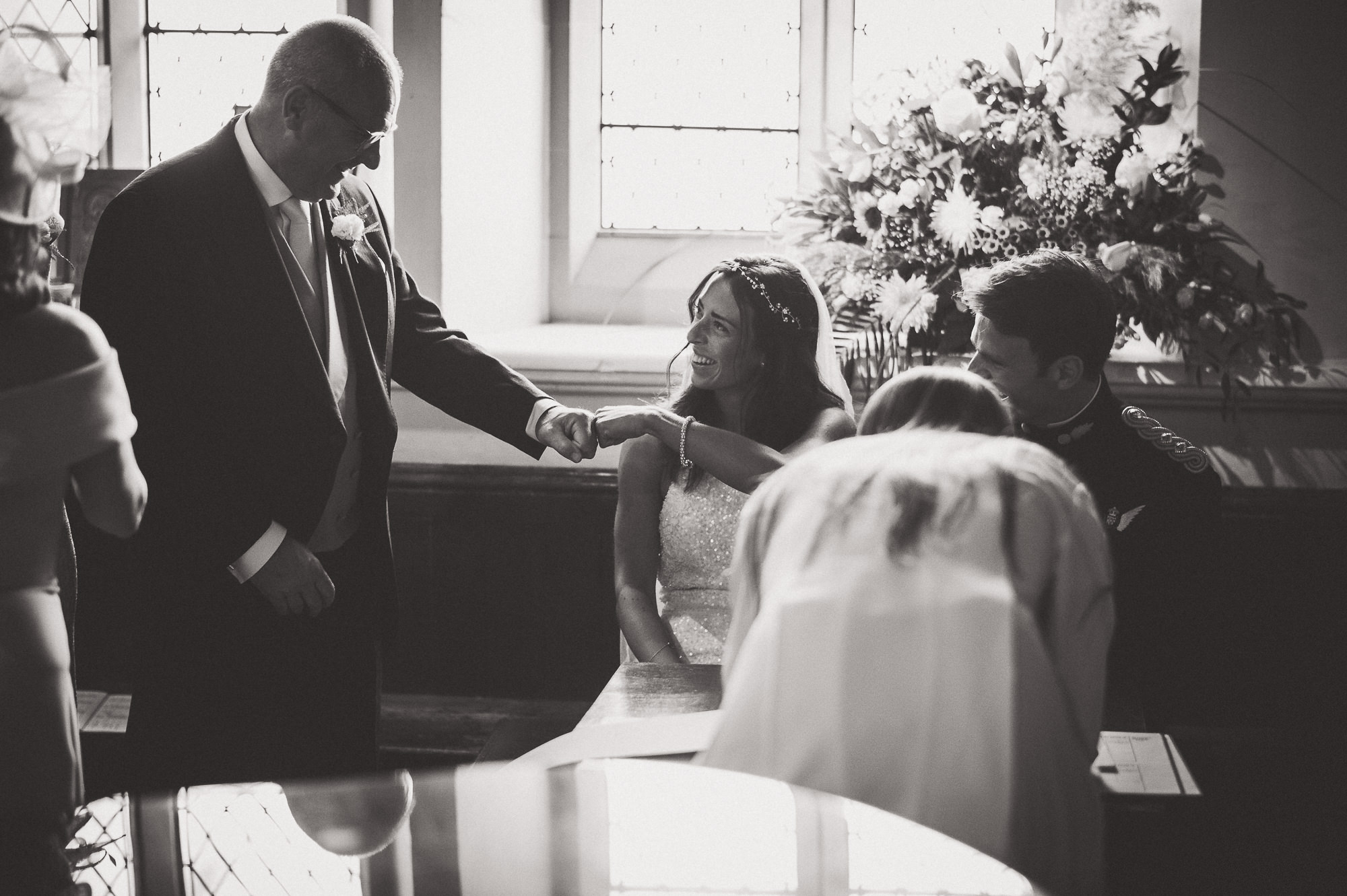 A bride and groom pose for their wedding photo in a church.