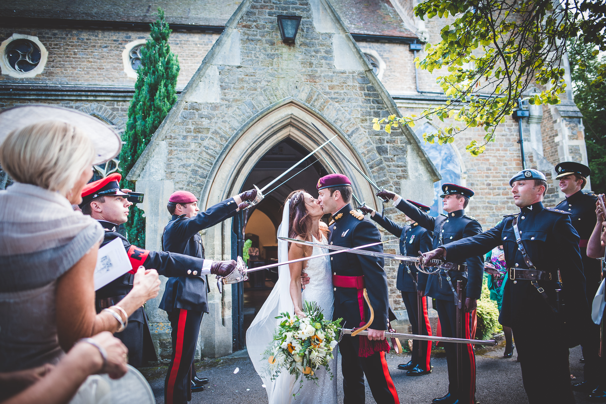 A wedding photo capturing a bride and groom kissing in front of the church.