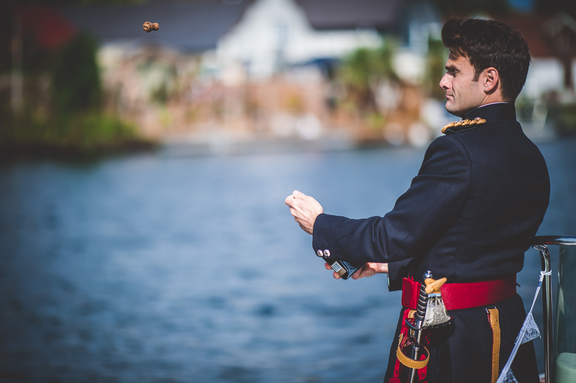 A man in a military uniform throwing a frisbee at a wedding reception.