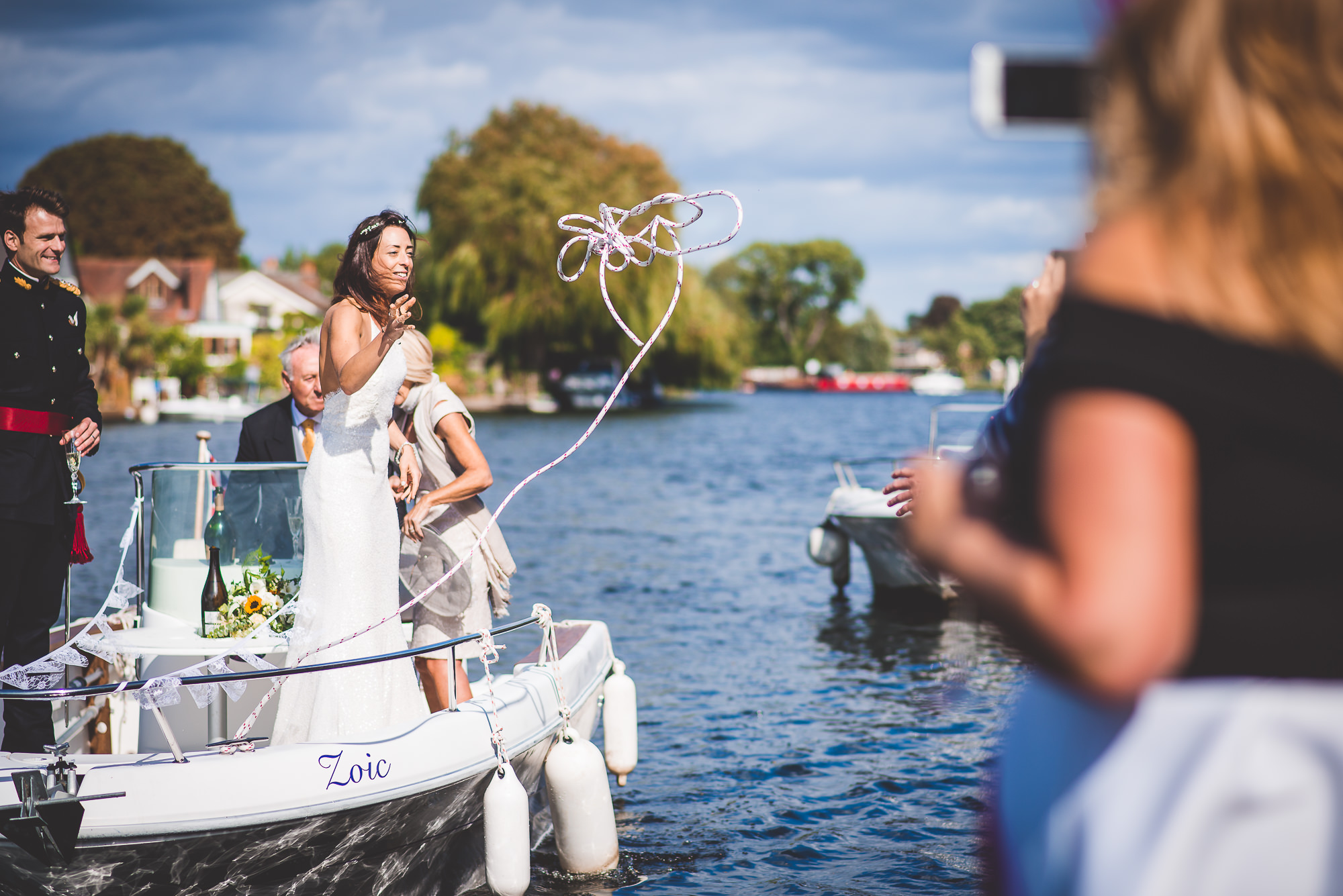 A wedding photo of the groom and bride on a boat with balloons.