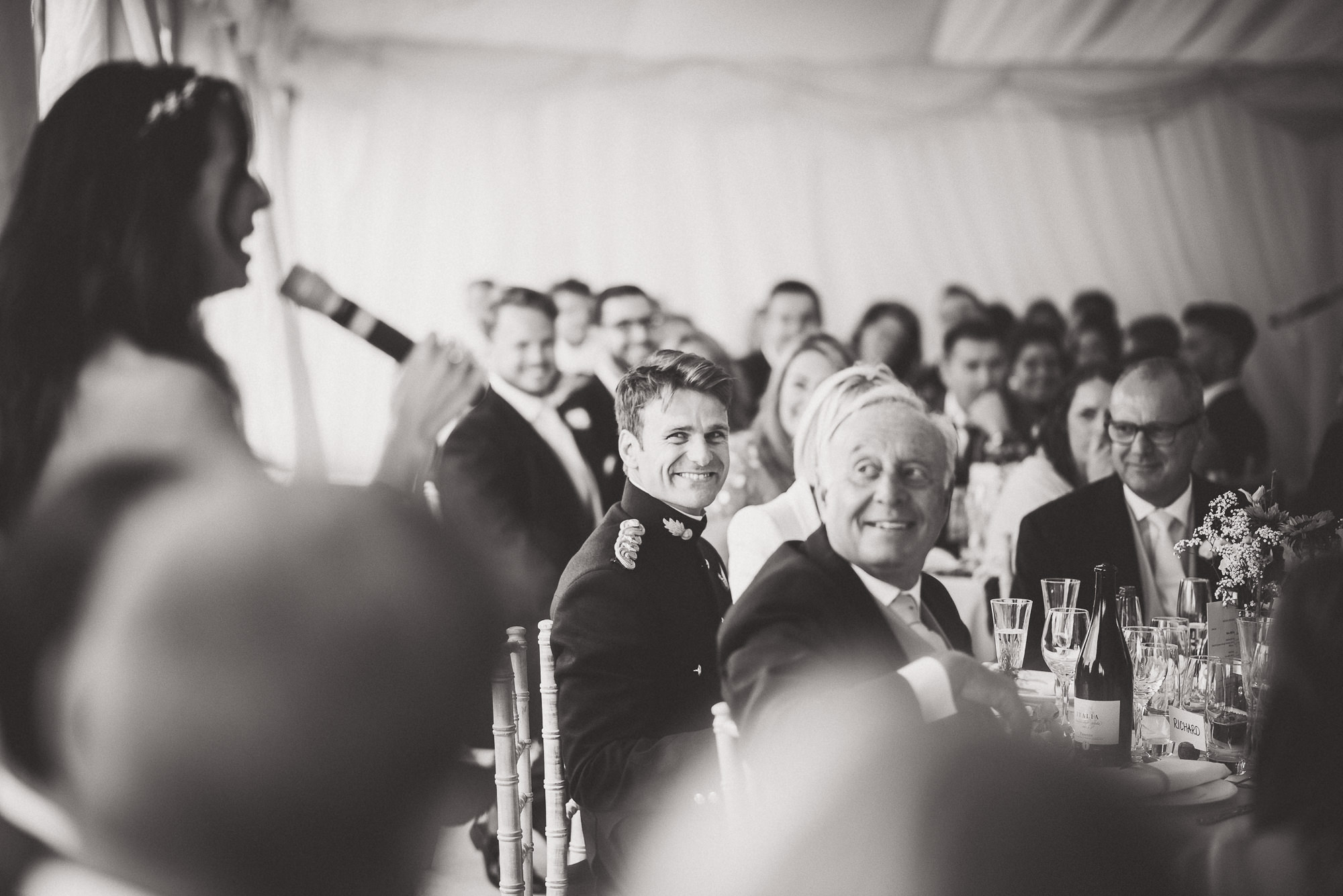 A wedding photo capturing a man delivering a speech.