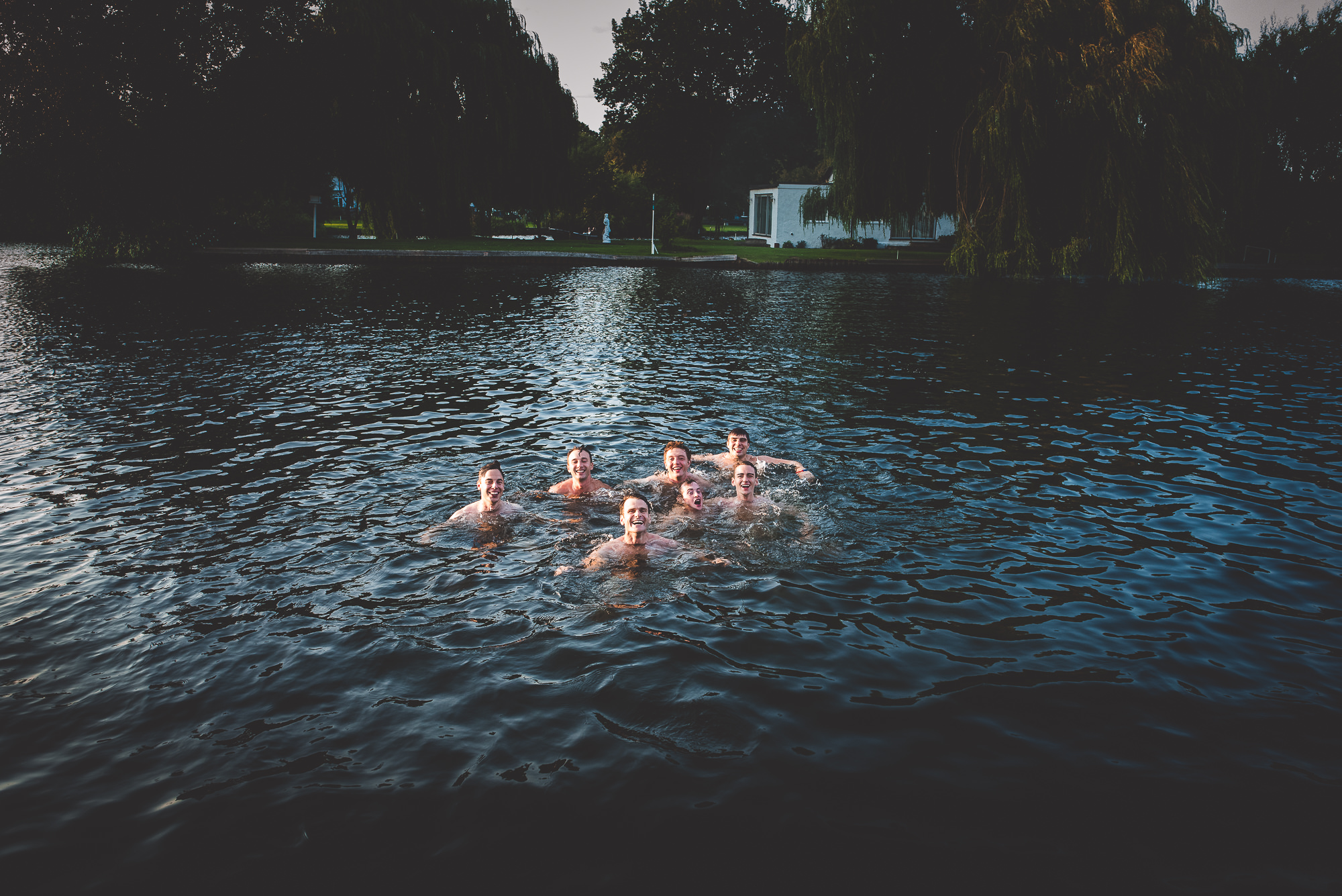A wedding party swimming in the water for a memorable photo.