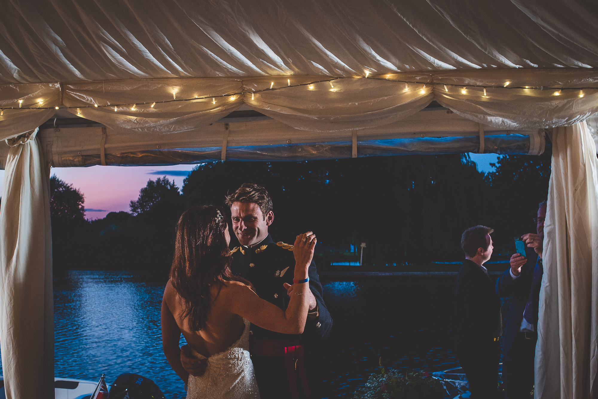A groom and bride dance in front of a tent as captured by their wedding photographer.