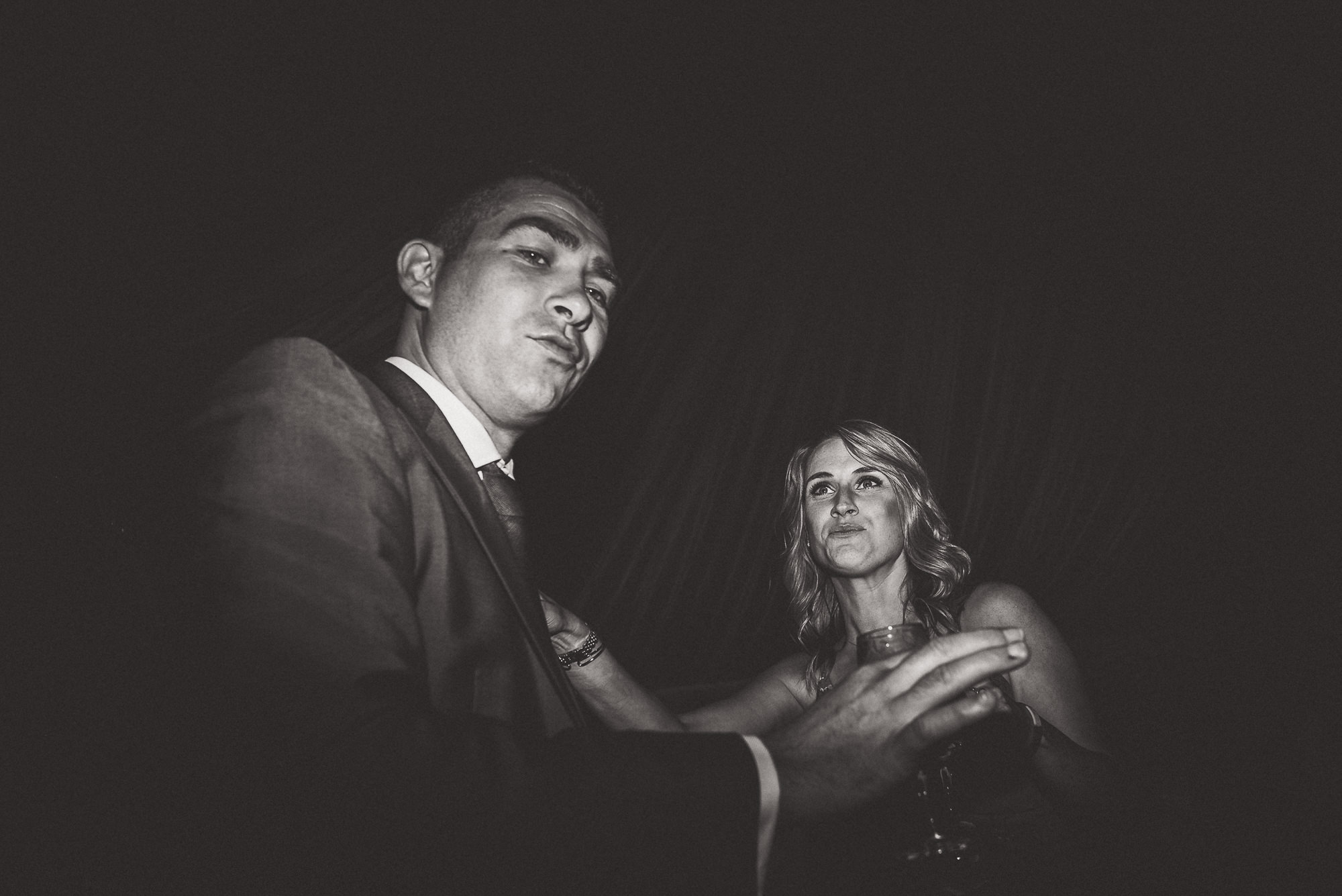 A black and white photo capturing the bride and groom dancing at their wedding.