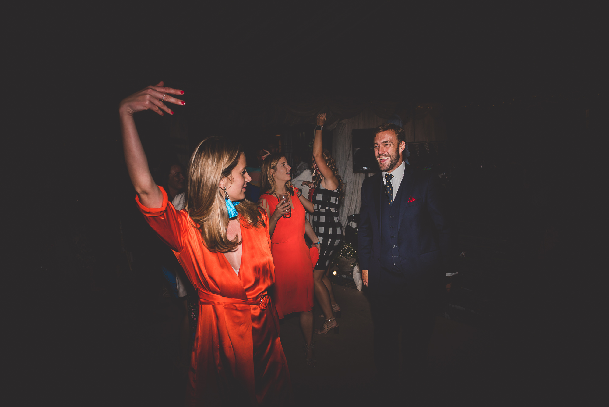 A wedding party dancing in a dark room.