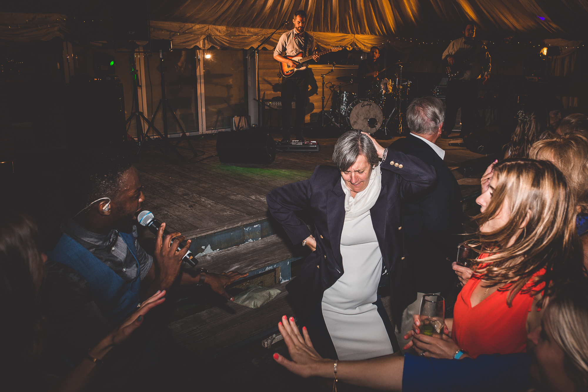 A wedding party dancing in a tent.