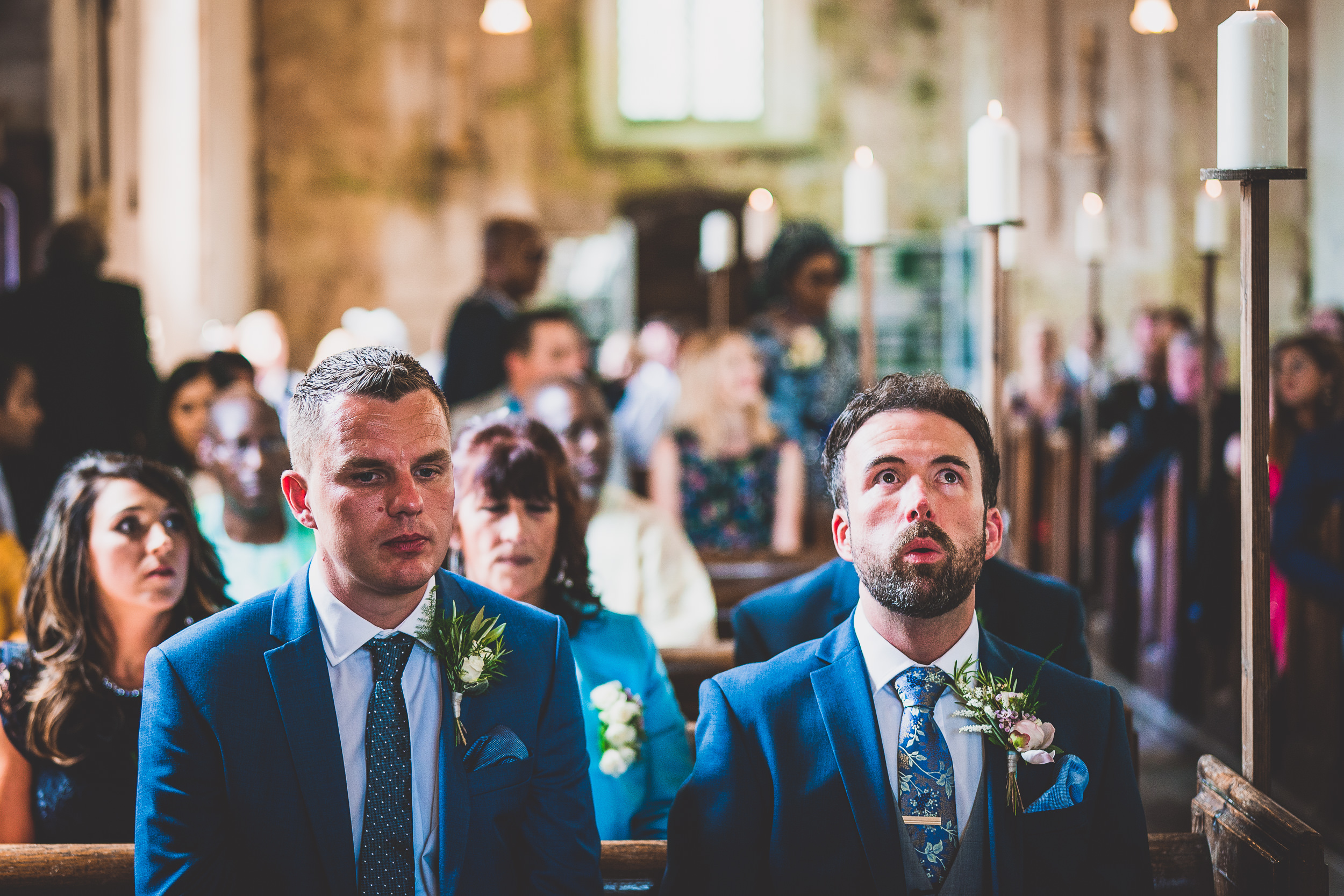 A wedding photo capturing a traditional church ceremony with the bride and groom seated in the pews.