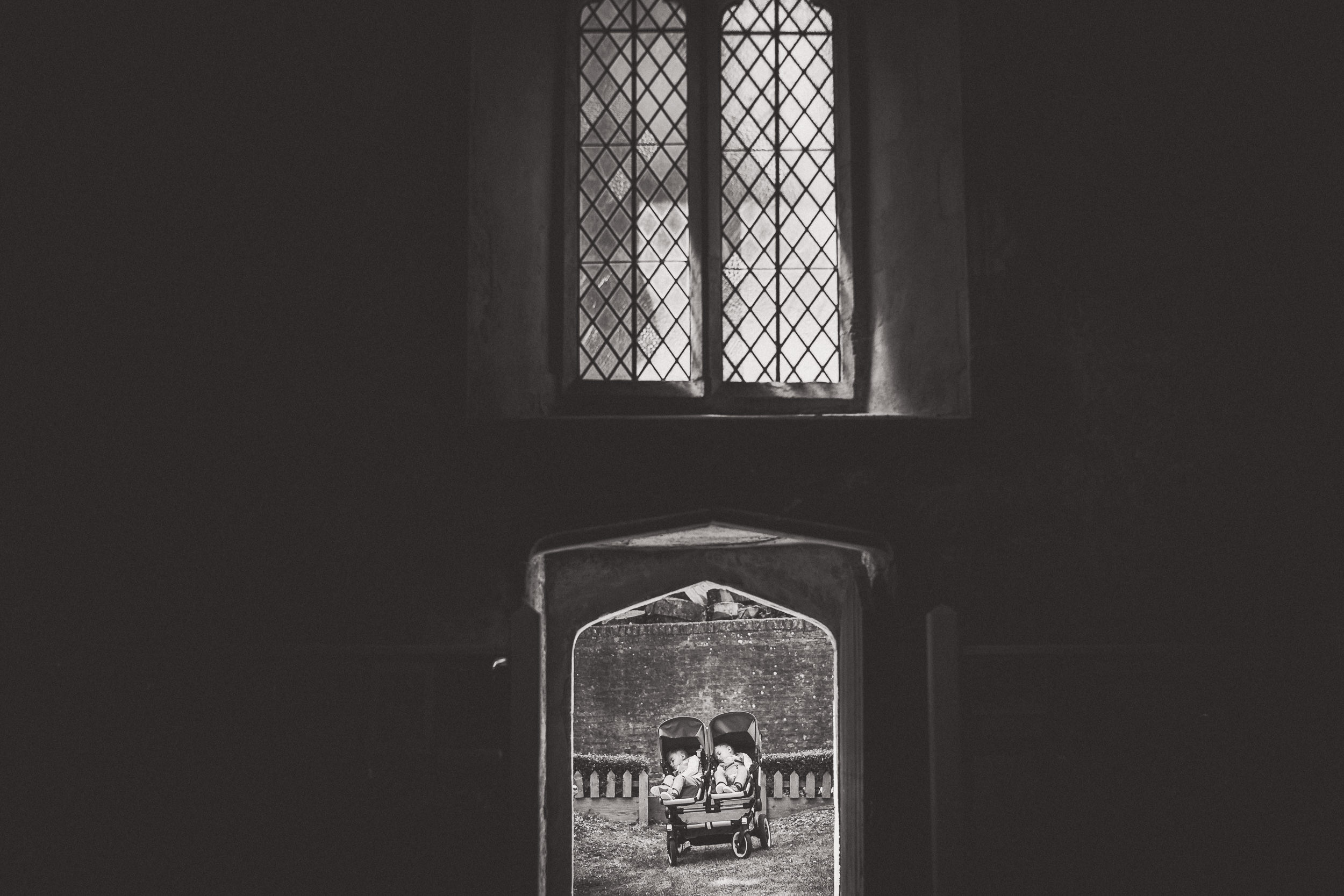 A black and white wedding photo of a couple sitting in a doorway.