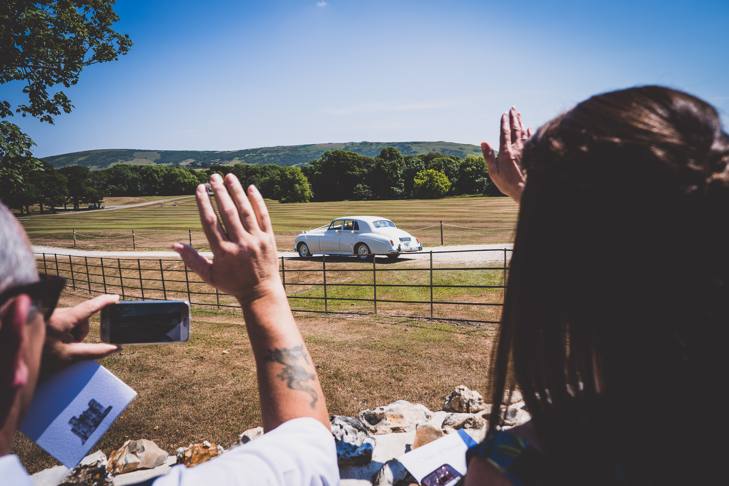 A wedding photographer captures a picture of the bride and groom's car.