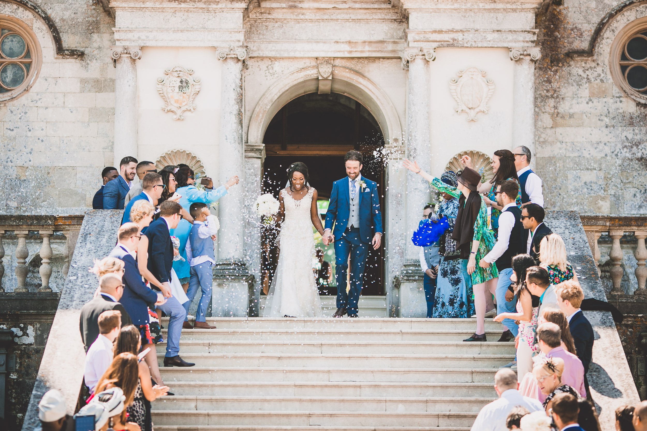 A groom and bride captured in a wedding photo, descending the steps of an old building, taken by a skilled wedding photographer.