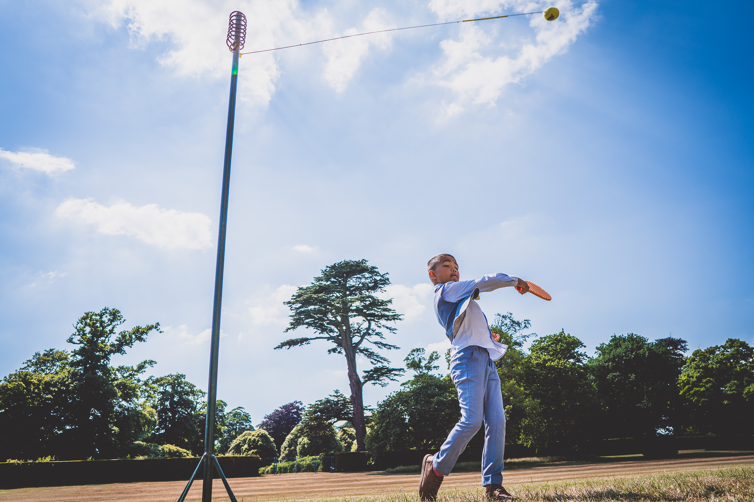 A groom throwing a frisbee in a field for his wedding photo.