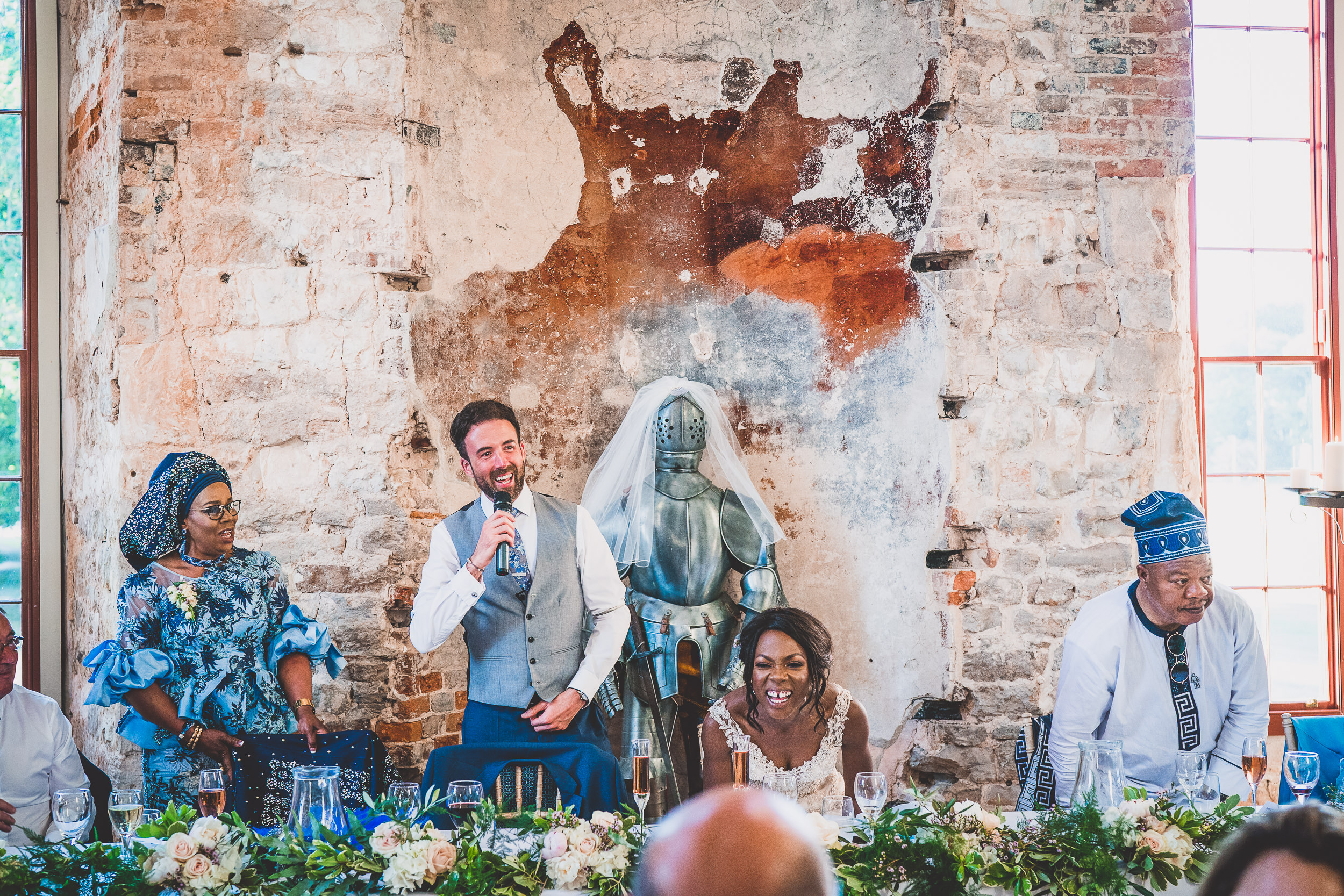 A groom giving a speech at a wedding reception, captured by the wedding photographer.