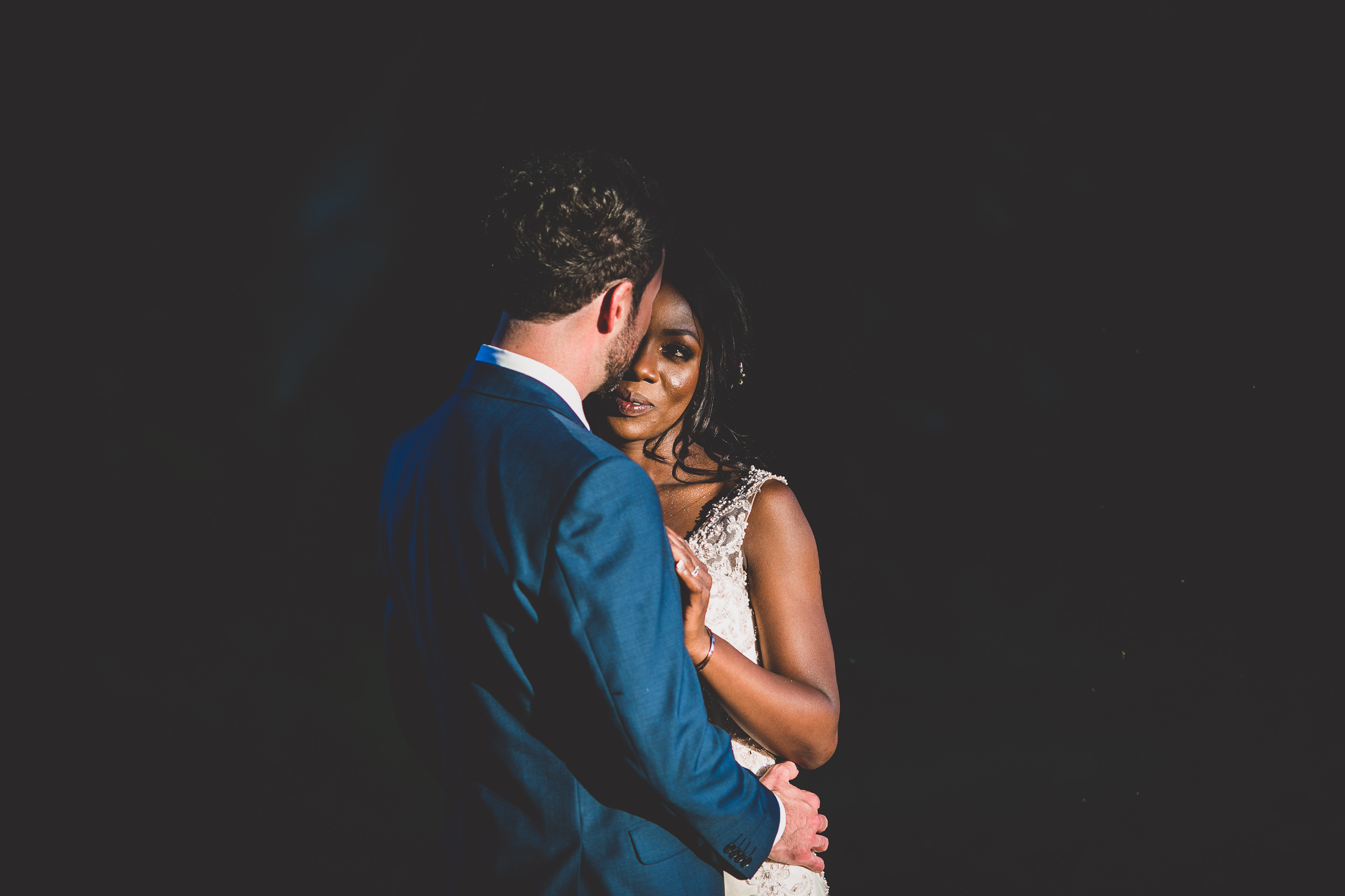 A wedding photo capturing the embrace of a bride and groom.