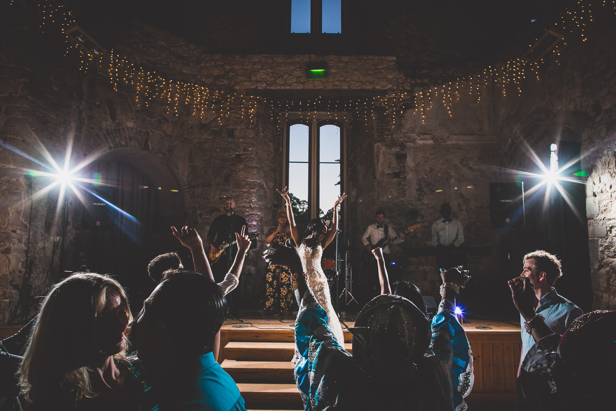 A wedding photographer captures the bride and groom dancing in a castle.