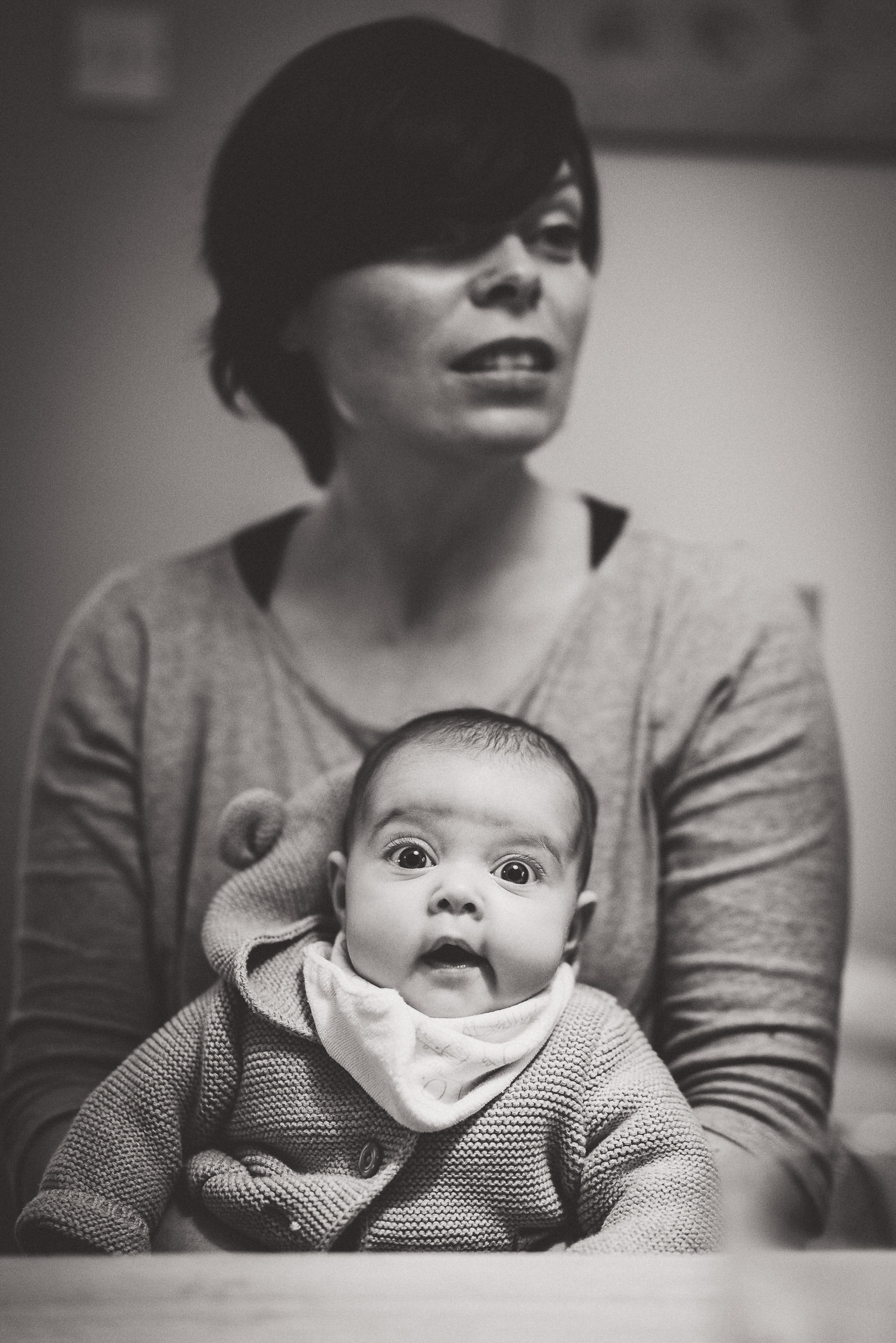 A black and white photo of a bride holding a baby.